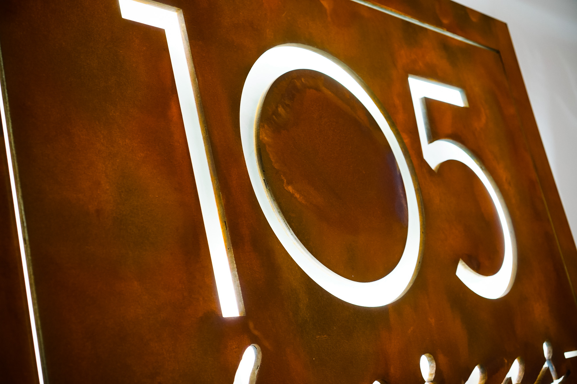 Rusted metal illuminated sign for 105 Degrees, a hot yoga studio at Newtown Athletic Club, a premiere family fitness and wellness center serving residents of Newtown, PA
