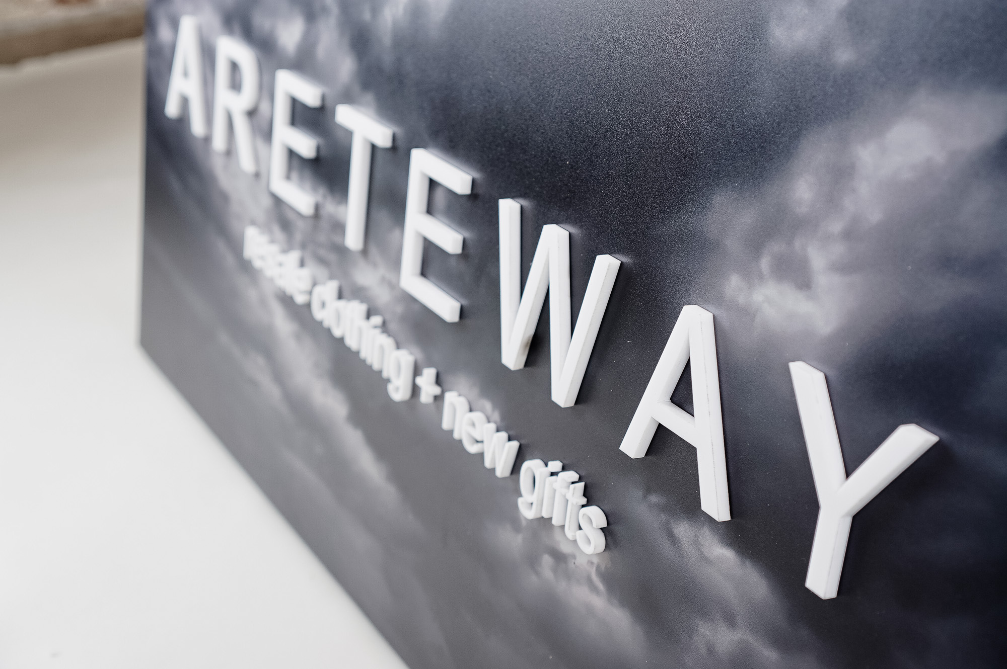 Exterior sign with black and white photo and raised white letters for Areteway, a clothing and gift boutique in Santa Rosa, CA. Exterior sign with black and white photo and raised white letters for Areteway, a clothing and gift boutique in Santa Rosa, CA.