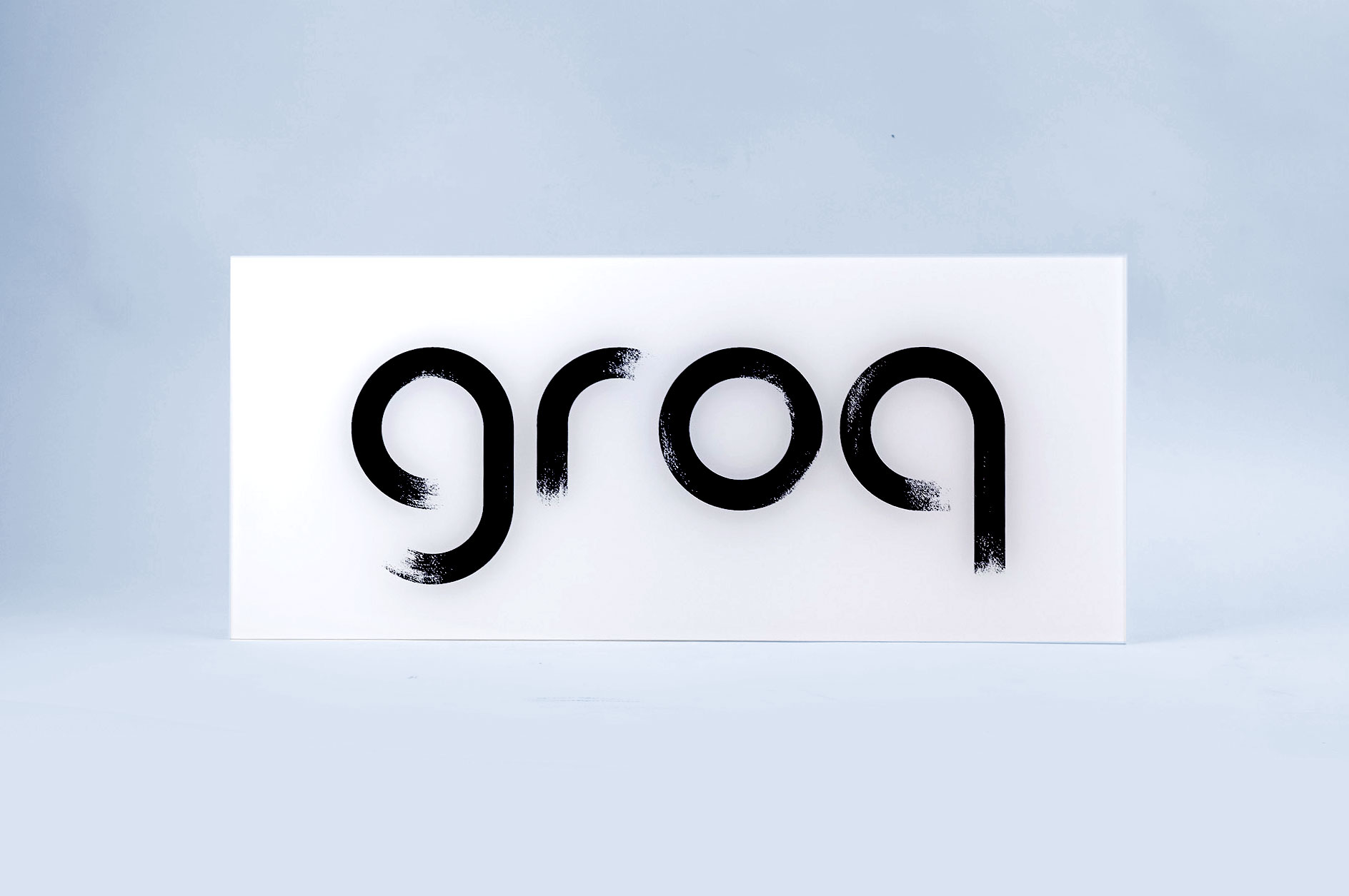 Glassy black and white sign with black brushstroke logo for Groq, a Palo Alto based company developing an integrated circuit developed specifically for machine learning.