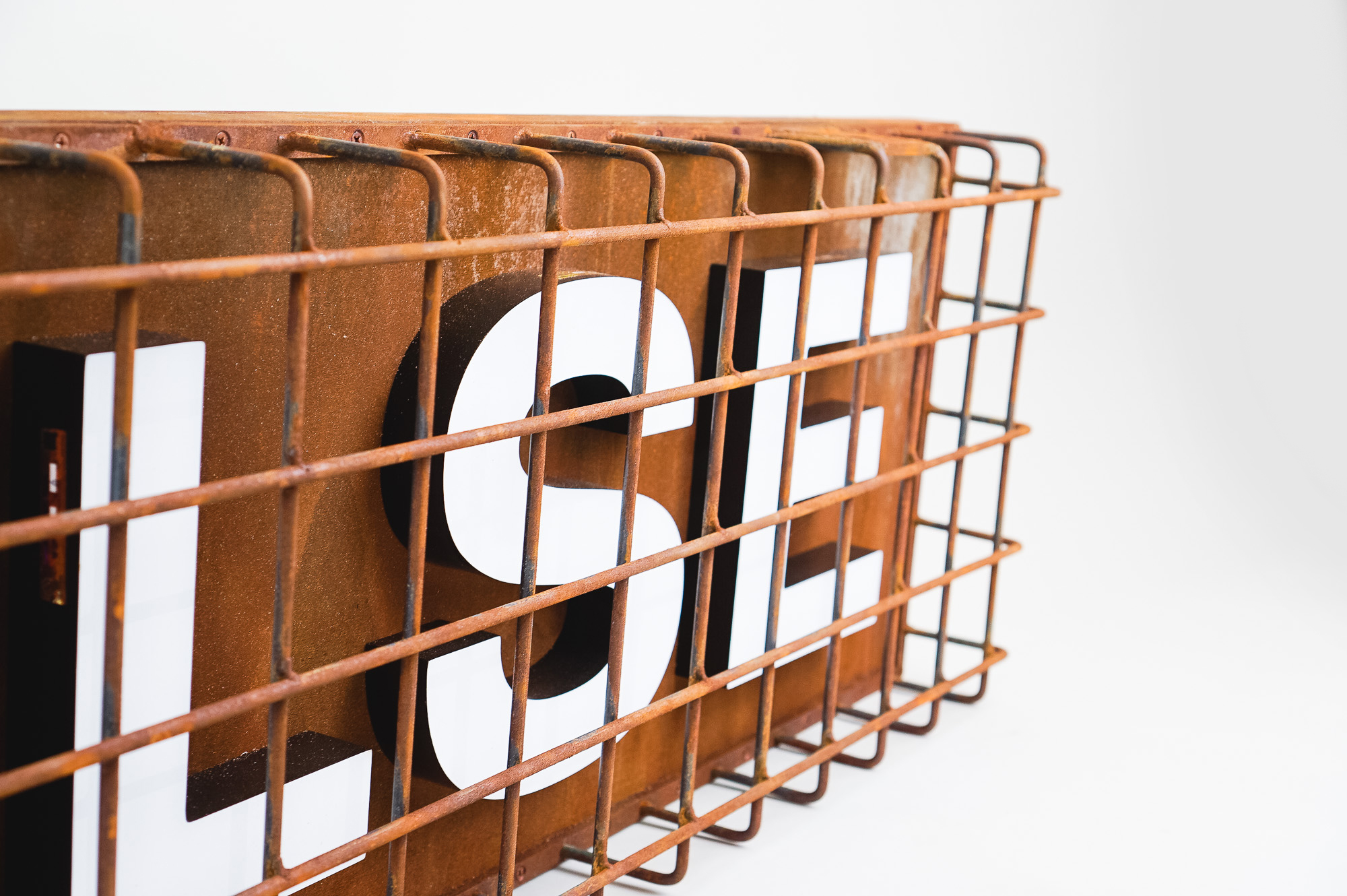 Industrial, caged, rusty metal illuminated sign for Pulse, a fitness studio at Newtown Athletic Club, a premiere family fitness and wellness center serving residents of Newtown, PA Industrial, caged, rusty metal illuminated sign for Pulse, a fitness studio at Newtown Athletic Club, a premiere family fitness and wellness center serving residents of Newtown, PA