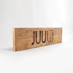 Reclaimed wood sign with etched logo for the San Francisco office of Juul, an electronic cigarette company.