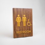 Gold and walnut wood ADA compliant restroom sign