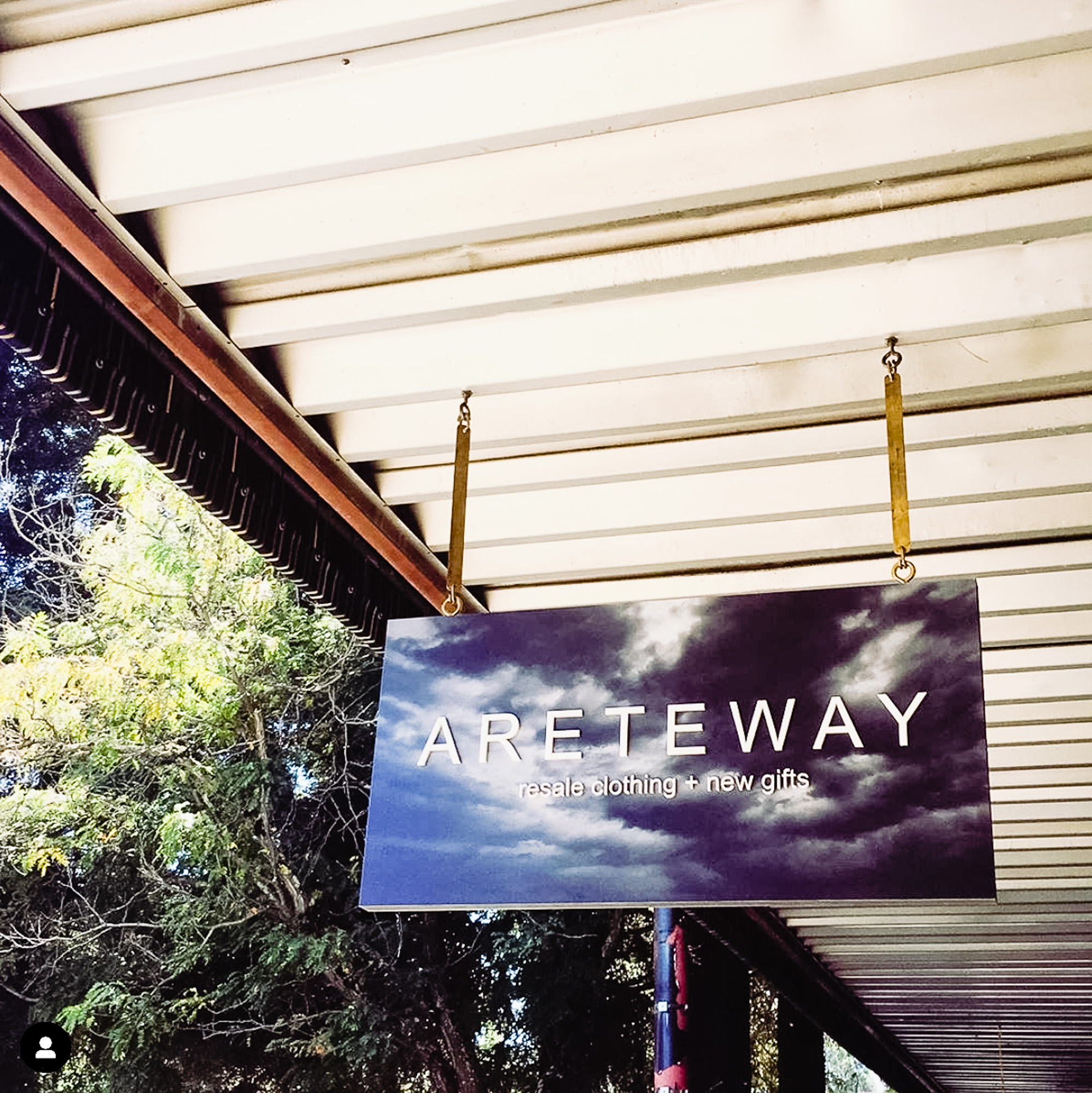 Exterior sign with black and white photo and raised white letters for Areteway, a clothing and gift boutique in Santa Rosa, CA.