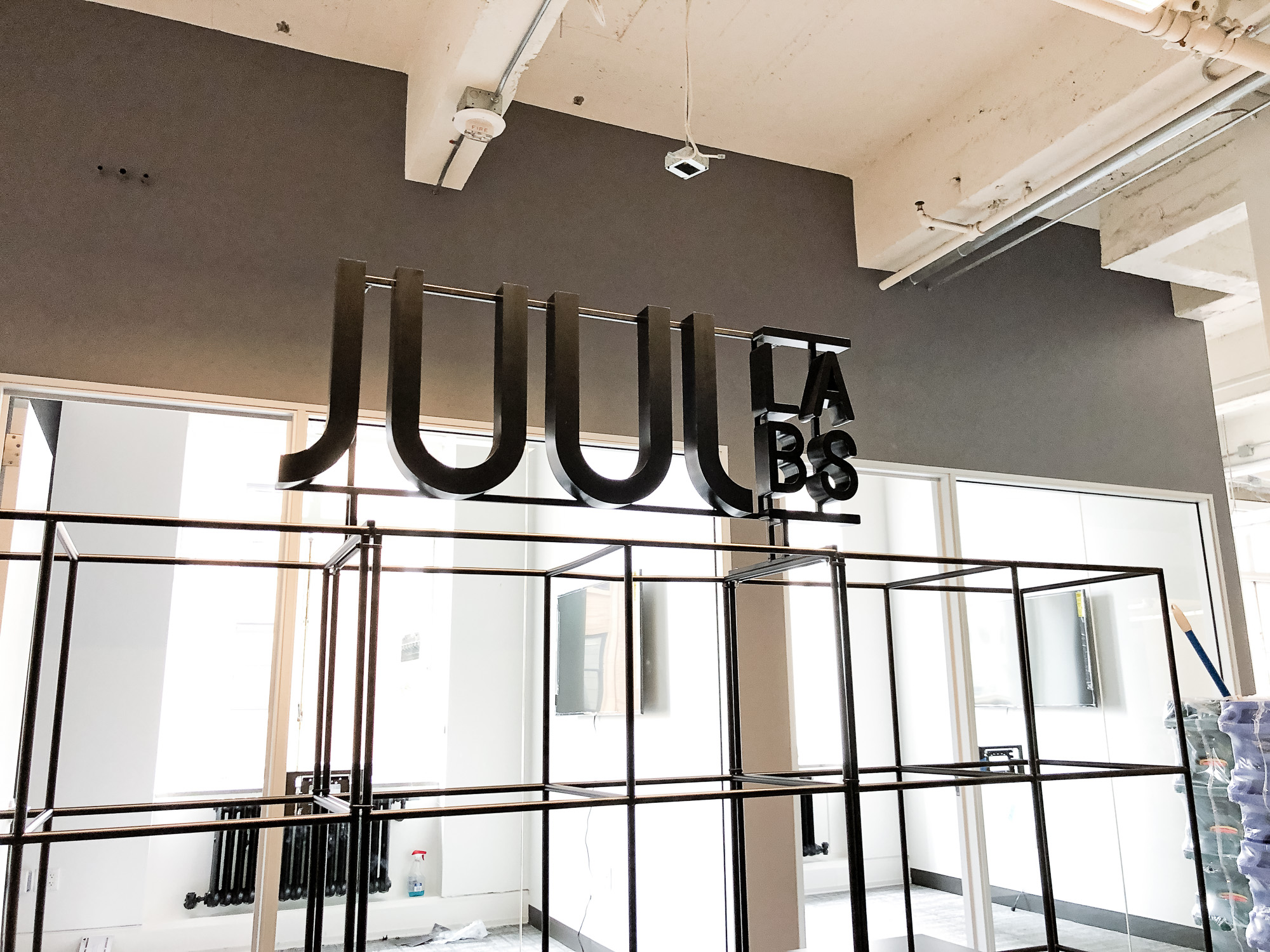 Black metal floating letter shelf sign for the San Francisco office of Juul, an electronic cigarette company. Black metal floating letter shelf sign for the San Francisco office of Juul, an electronic cigarette company.