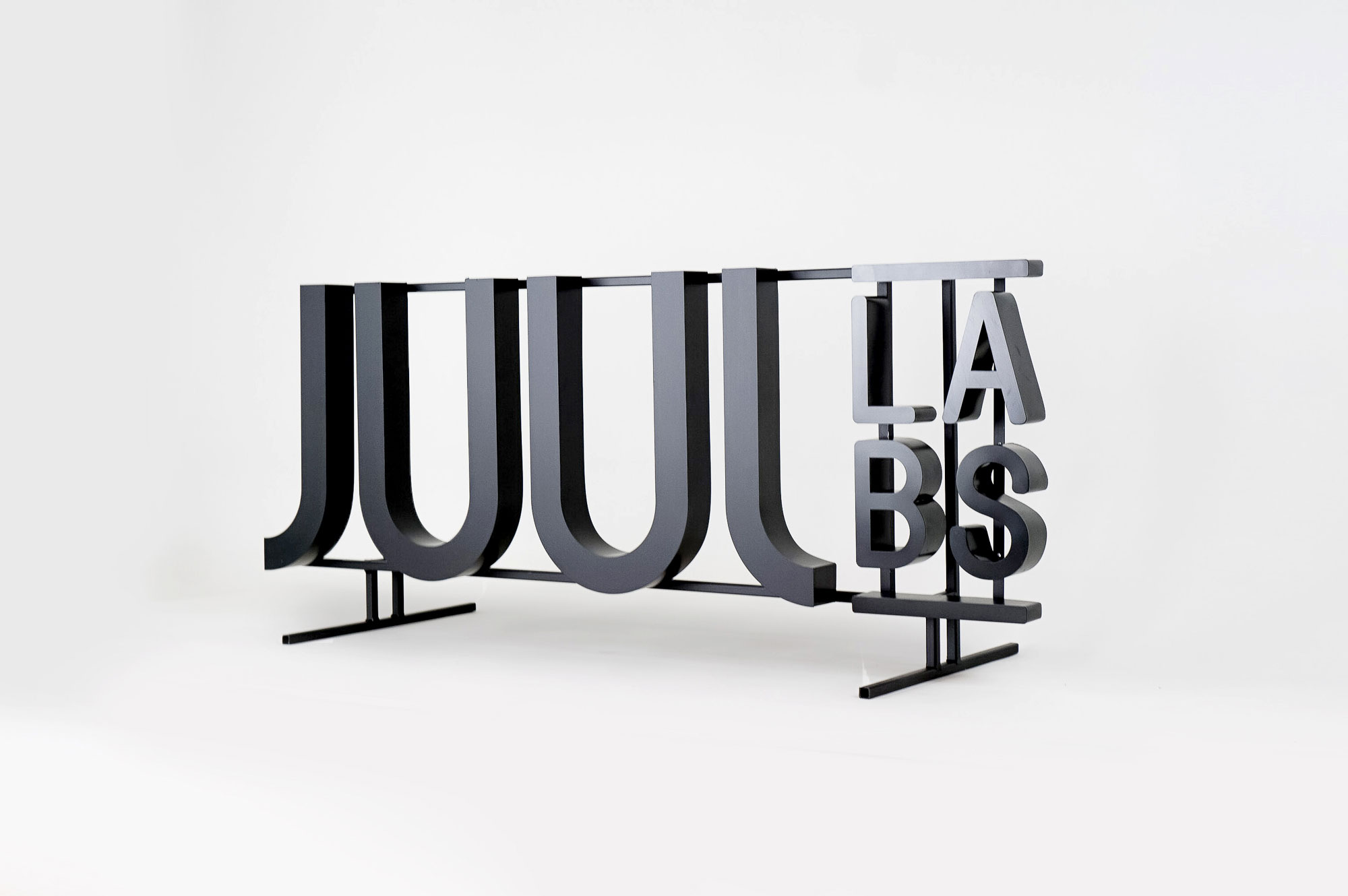 Black metal floating letter shelf sign for the San Francisco office of Juul, an electronic cigarette company.