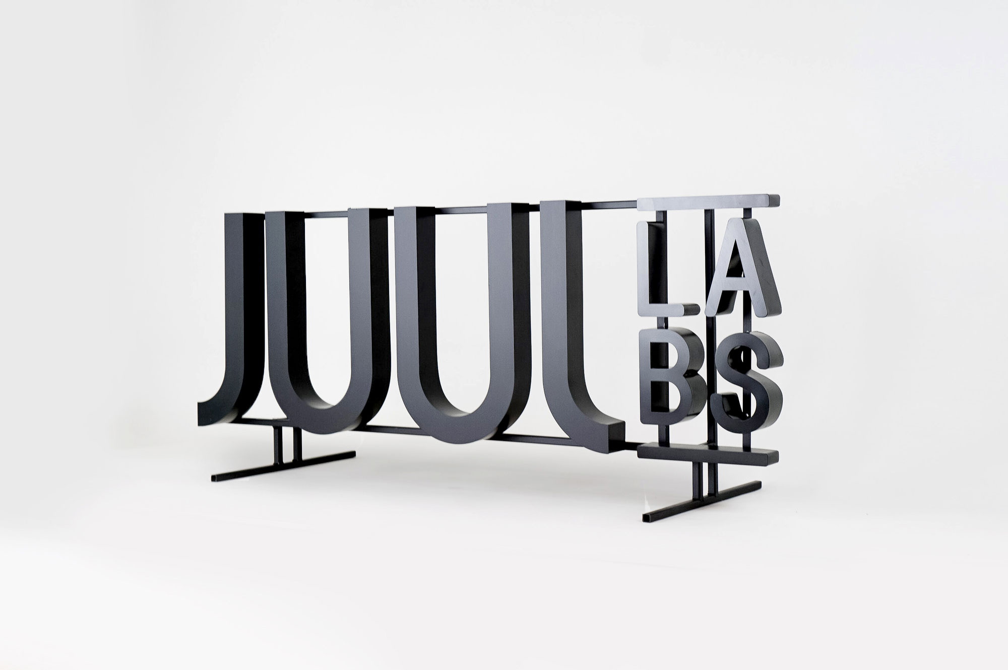 Black metal floating letter shelf sign for the San Francisco office of Juul, an electronic cigarette company. Black metal floating letter shelf sign for the San Francisco office of Juul, an electronic cigarette company.