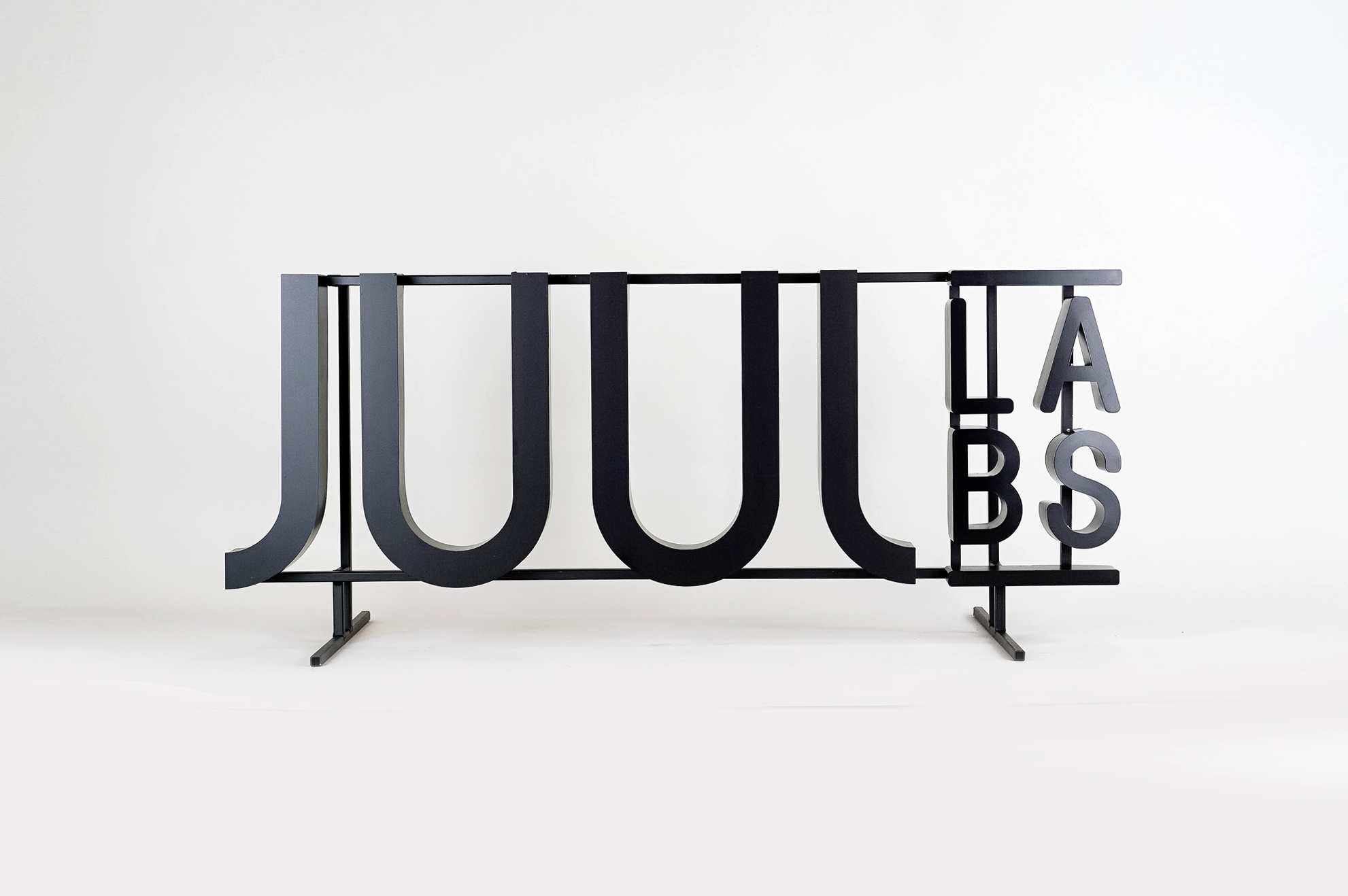 Black metal floating letter shelf sign for the San Francisco office of Juul, an electronic cigarette company. Black metal floating letter shelf sign for the San Francisco office of Juul, an electronic cigarette company.