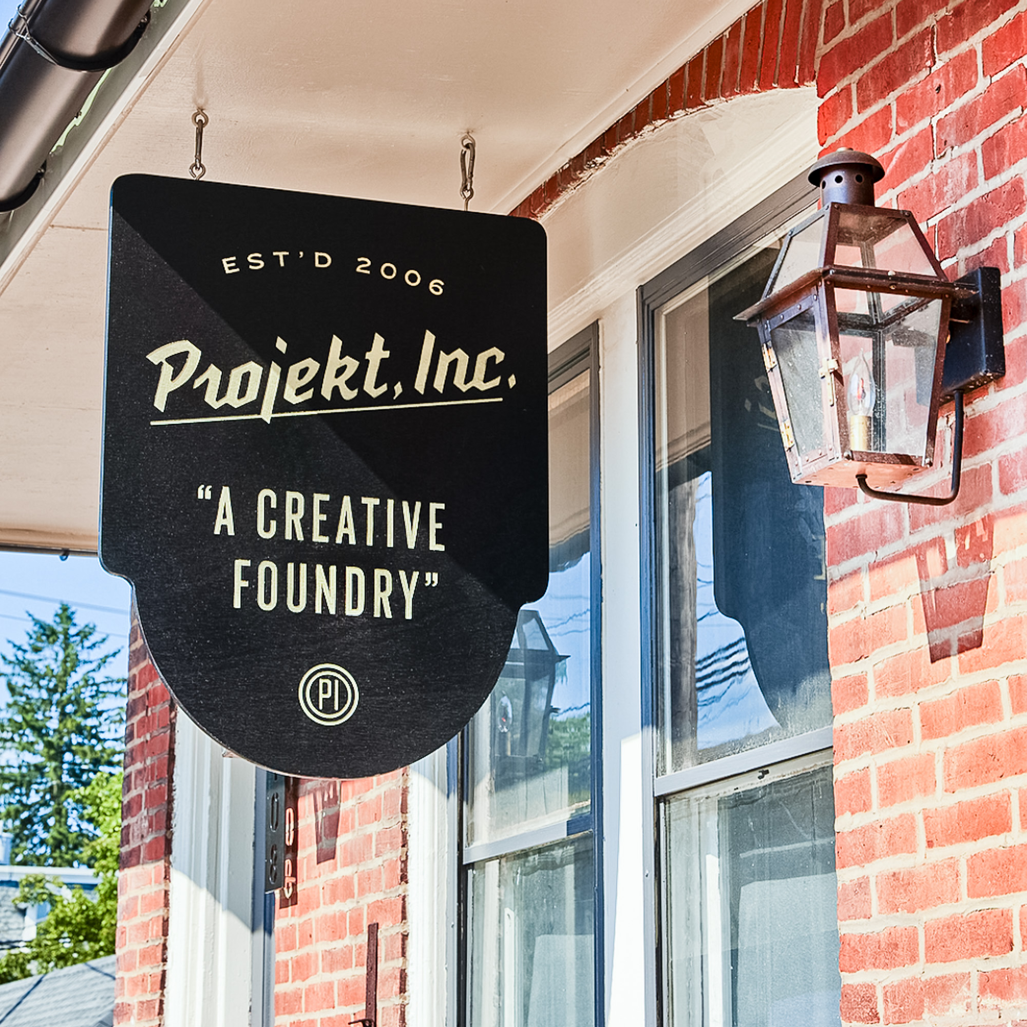 Suspended nodern black entrance sign for Projekt, a creative foundry in North Wales, PA Suspended nodern black entrance sign for Projekt, a creative foundry in North Wales, PA
