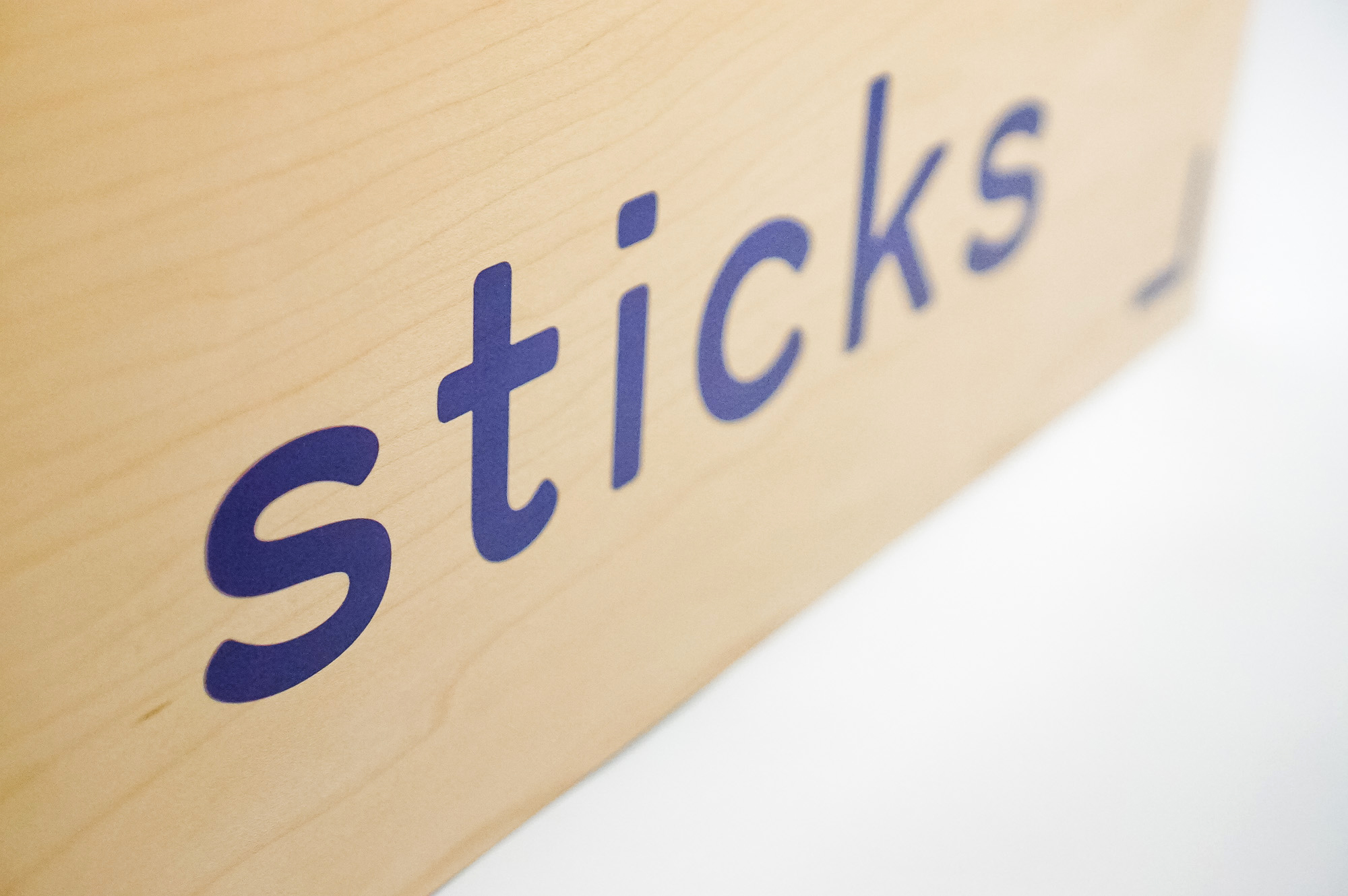 Light wood event sign with blue logo for Sticks, a kidswear company. Light wood event sign with blue logo for Sticks, a kidswear company.
