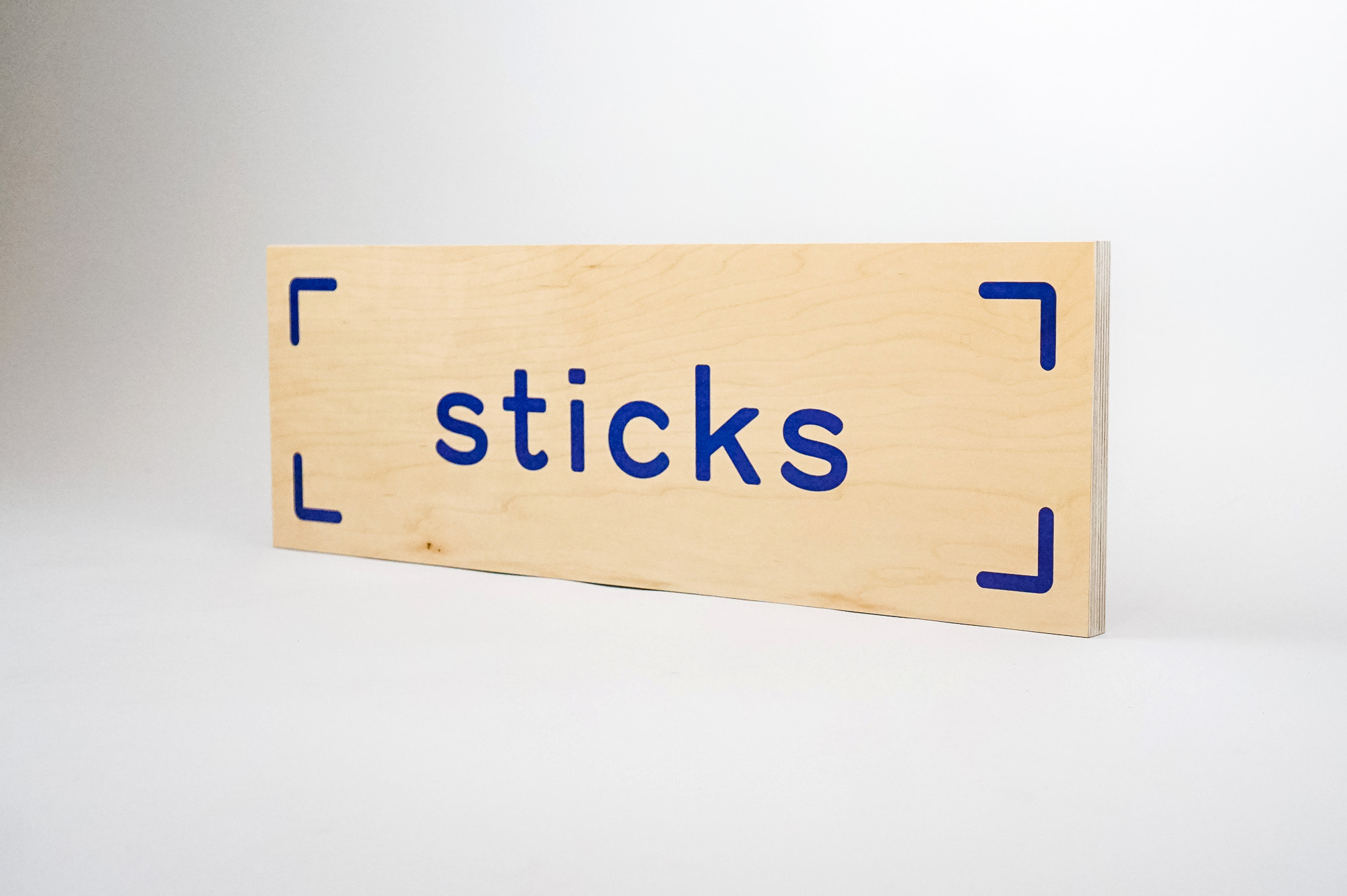 Light wood event sign with blue logo for Sticks, a kidswear company. Light wood event sign with blue logo for Sticks, a kidswear company.