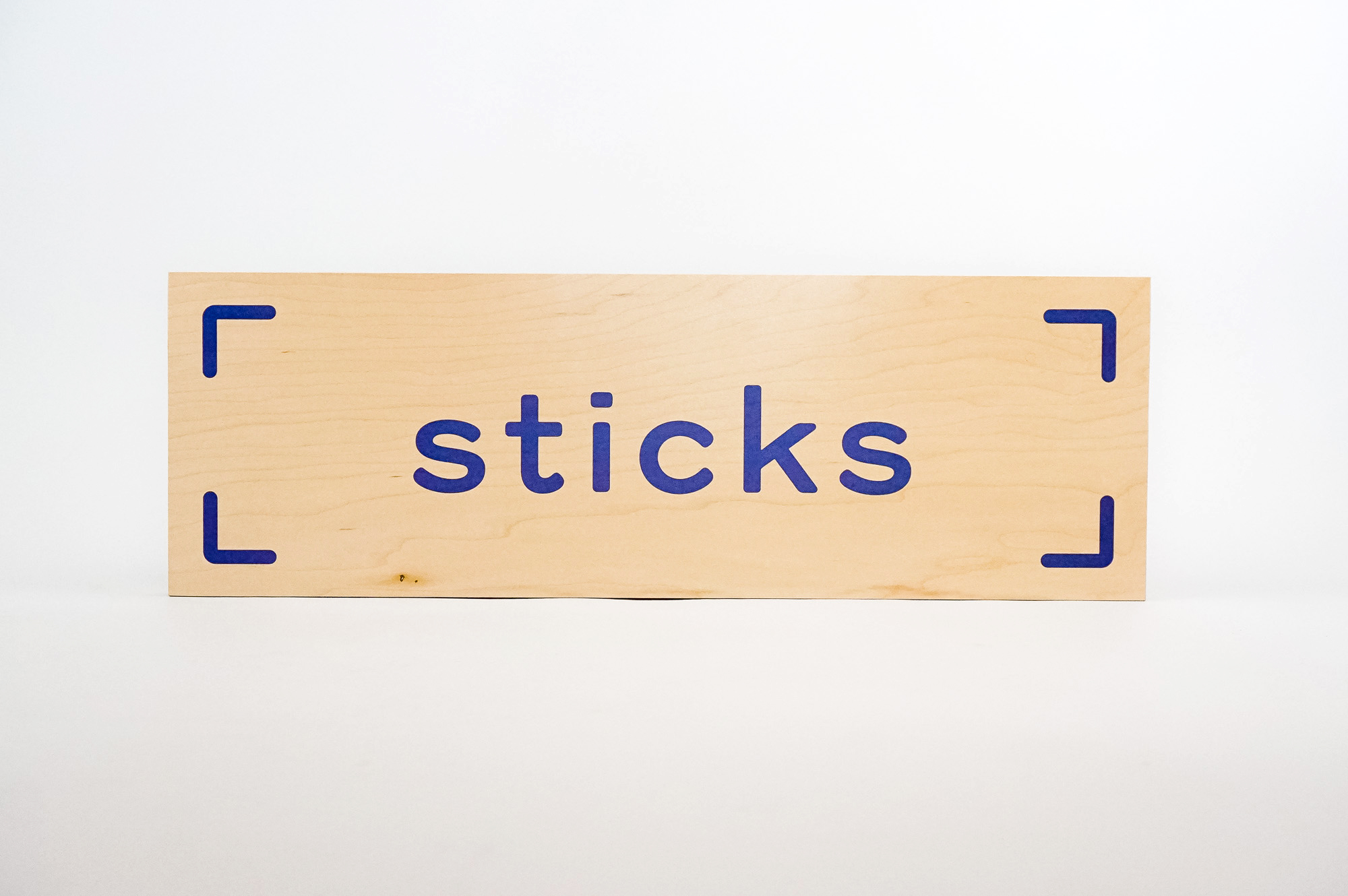 Light wood event sign with blue logo for Sticks, a kidswear company. Light wood event sign with blue logo for Sticks, a kidswear company.