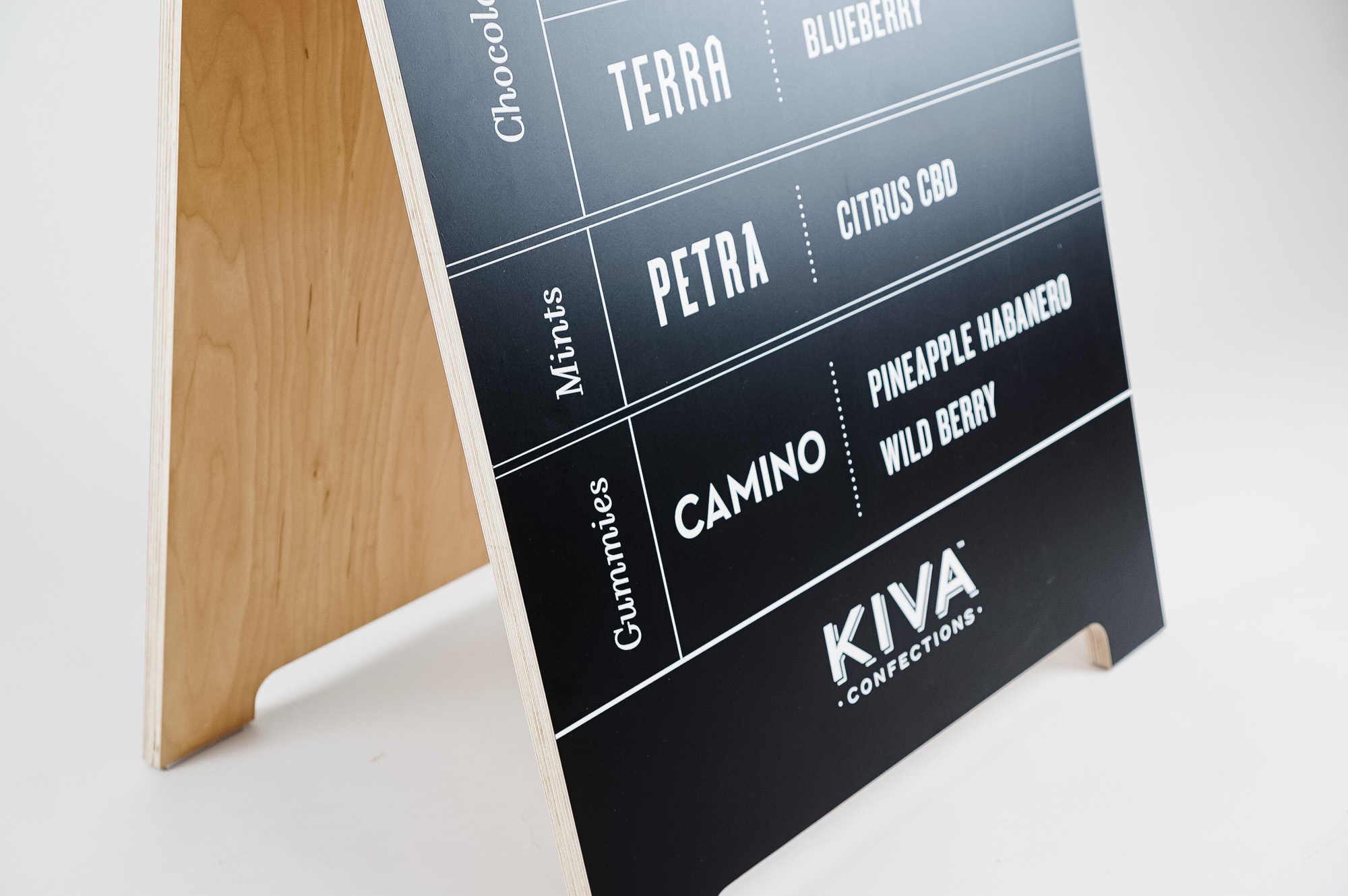 Black and white A-frame menu sign for the Outside Lands booth of Kiva, creators of delicious varieties of cannabis-infused confections. Black and white A-frame menu sign for the Outside Lands booth of Kiva, creators of delicious varieties of cannabis-infused confections.