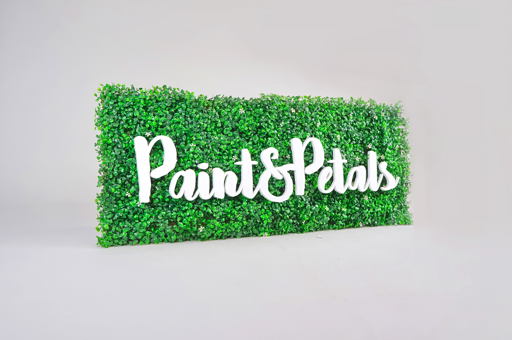 Faux boxwood sign with white script text for Paint & Petals, a California-based housewares collection created from Bridgette Thornton’s hand-painted designs. Faux boxwood sign with white script text for Paint & Petals, a California-based housewares collection created from Bridgette Thornton’s hand-painted designs.