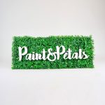 Faux boxwood sign with white script text for Paint & Petals, a California-based housewares collection created from Bridgette Thornton’s hand-painted designs.