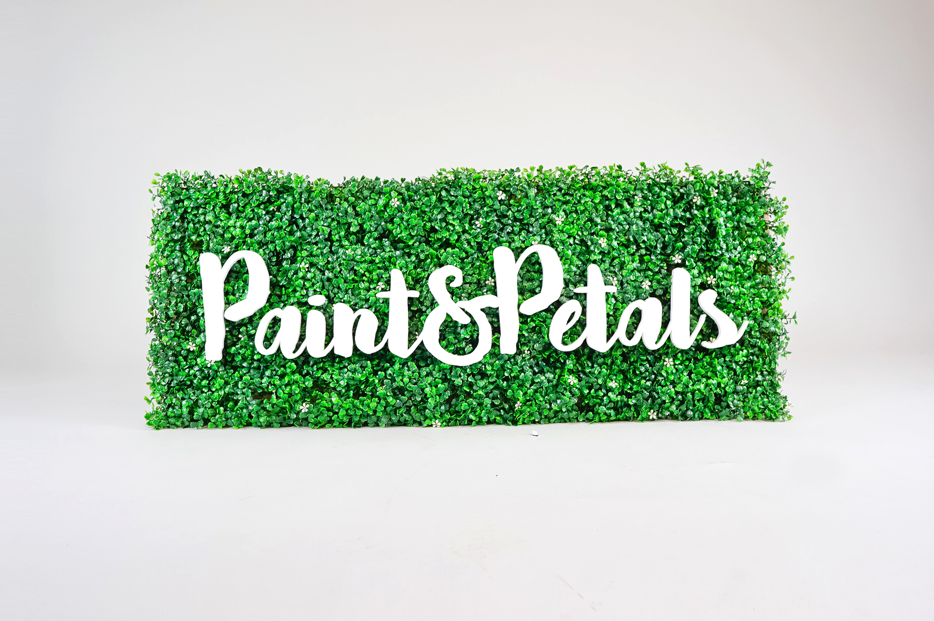 Faux boxwood sign with white script text for Paint & Petals, a California-based housewares collection created from Bridgette Thornton’s hand-painted designs. Faux boxwood sign with white script text for Paint & Petals, a California-based housewares collection created from Bridgette Thornton’s hand-painted designs.