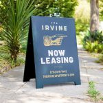 Emerald green and gold A-frame sign for The Irvine, a luxury apartment building in Philadelphia.