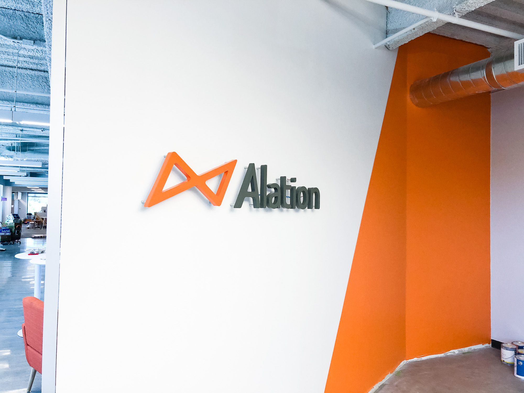 Illuminated black and orange lobby sign on color blocked wall for Alation, a data catalog company based in Redwood City, CA Illuminated black and orange lobby sign on color blocked wall for Alation, a data catalog company based in Redwood City, CA