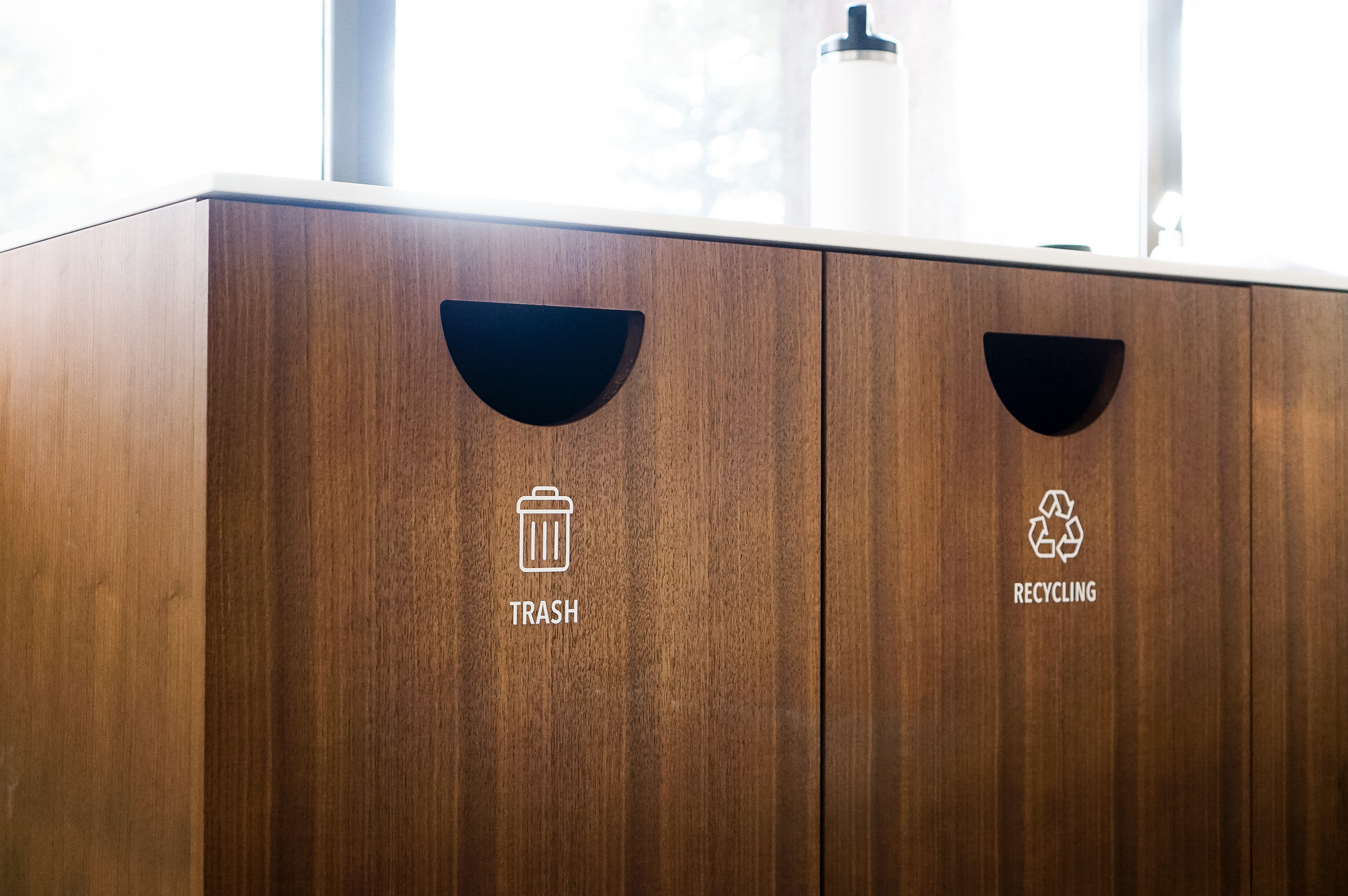Minimal white vinyl signage /decals for wood trash, compost, and recycling bins at the office of Baker McKenzie, a multinational law firm. Minimal white vinyl signage /decals for wood trash, compost, and recycling bins at the office of Baker McKenzie, a multinational law firm.