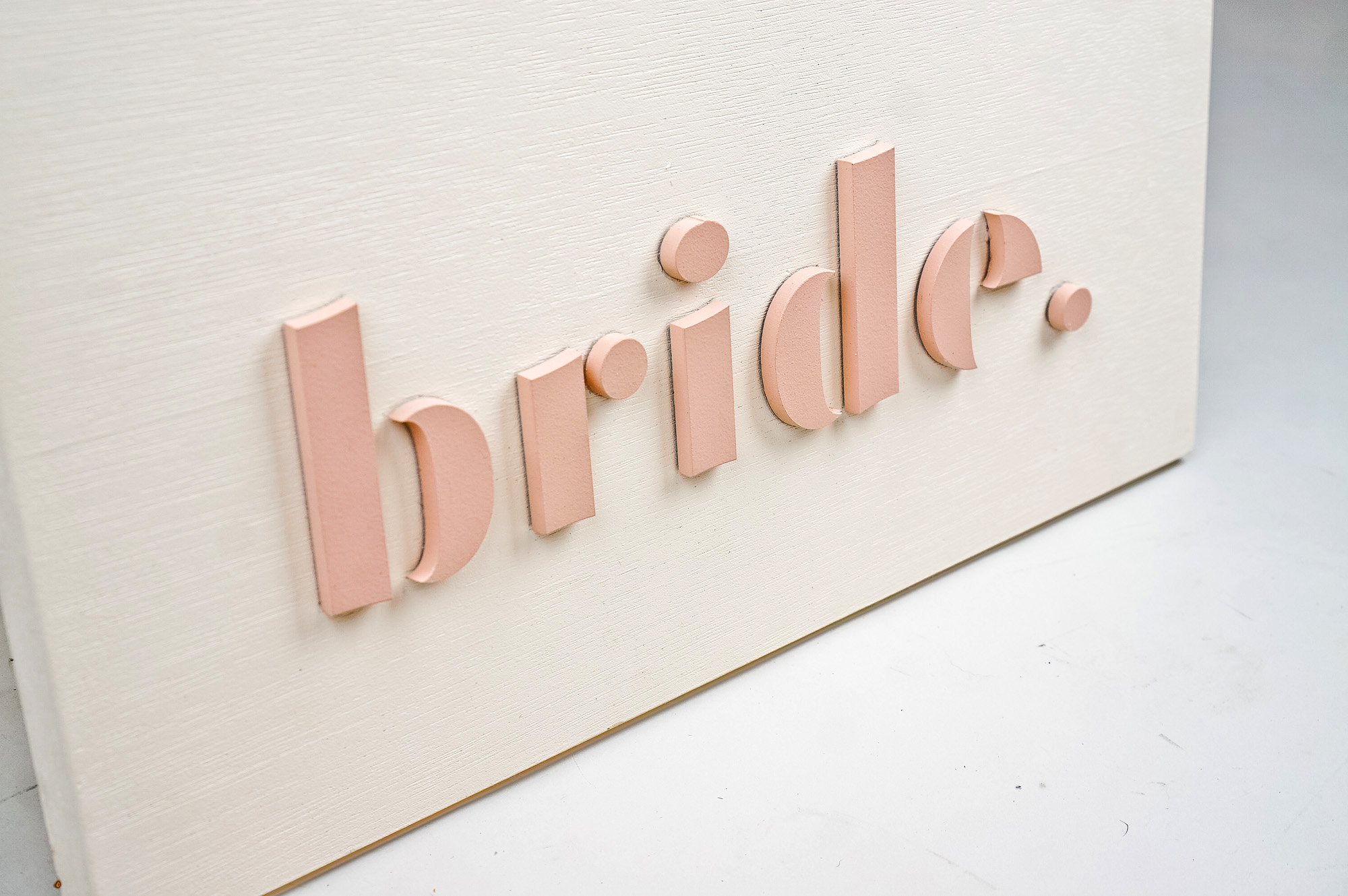 Blush-colored blade sign for Bride, a bridal shop in Kansas City, Missouri.