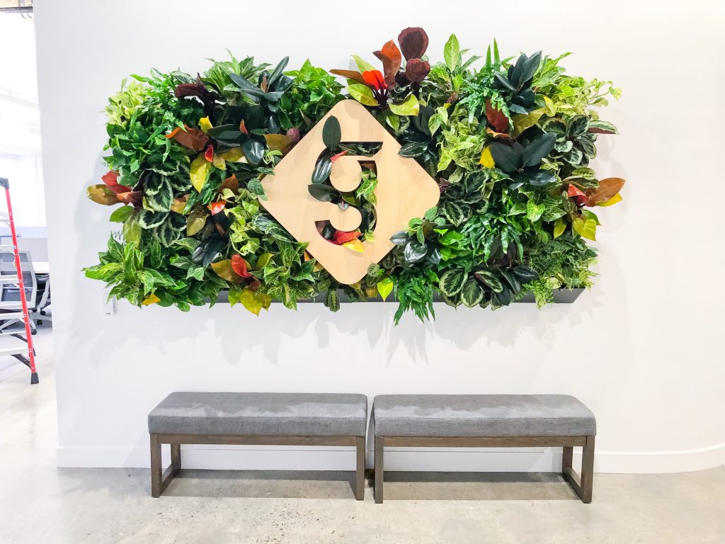 Light wood sign with colored edges on living wall for the lobby of Getaround, an online car sharing or peer-to-peer carsharing service.