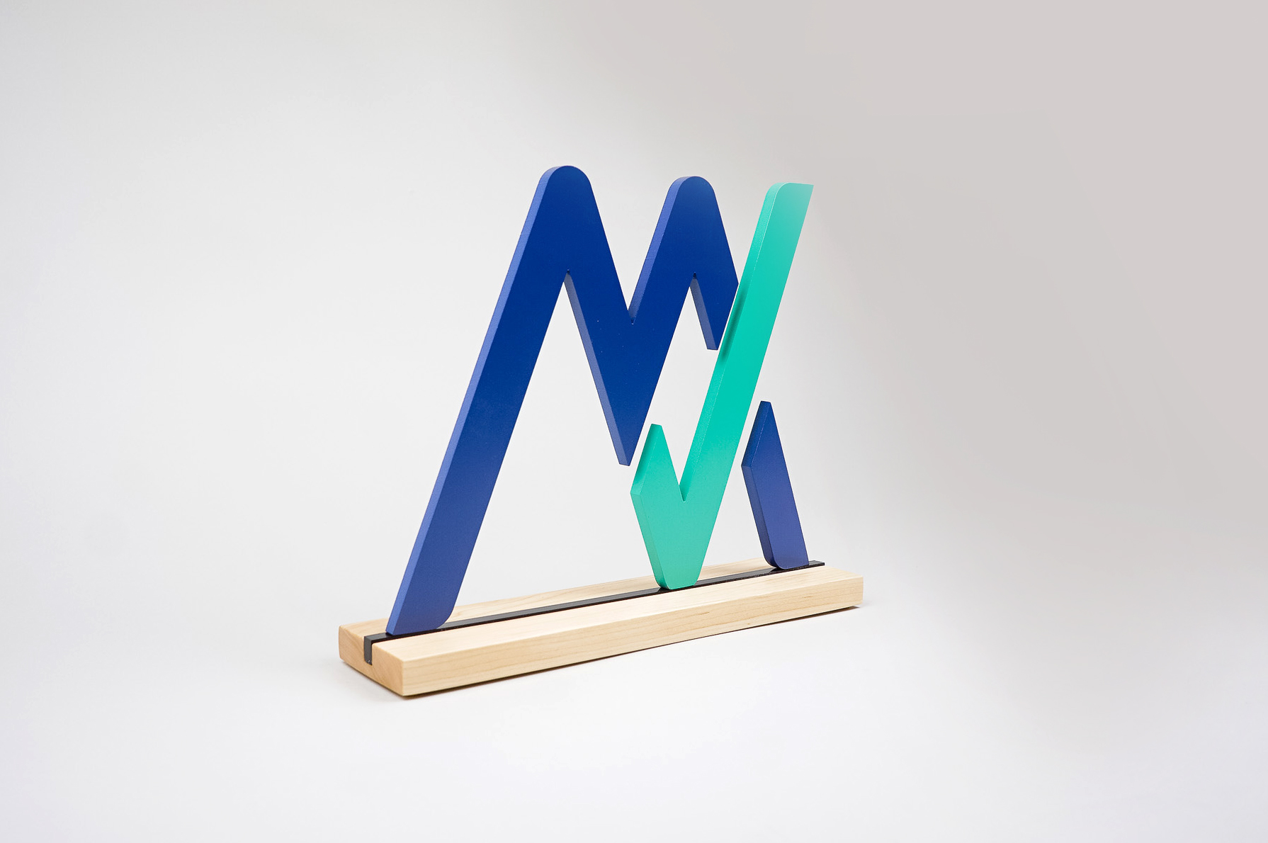 Freestanding blue and green logo on wood base for the office of MyVest, a company building enterprise wealth management technology for the digital age.