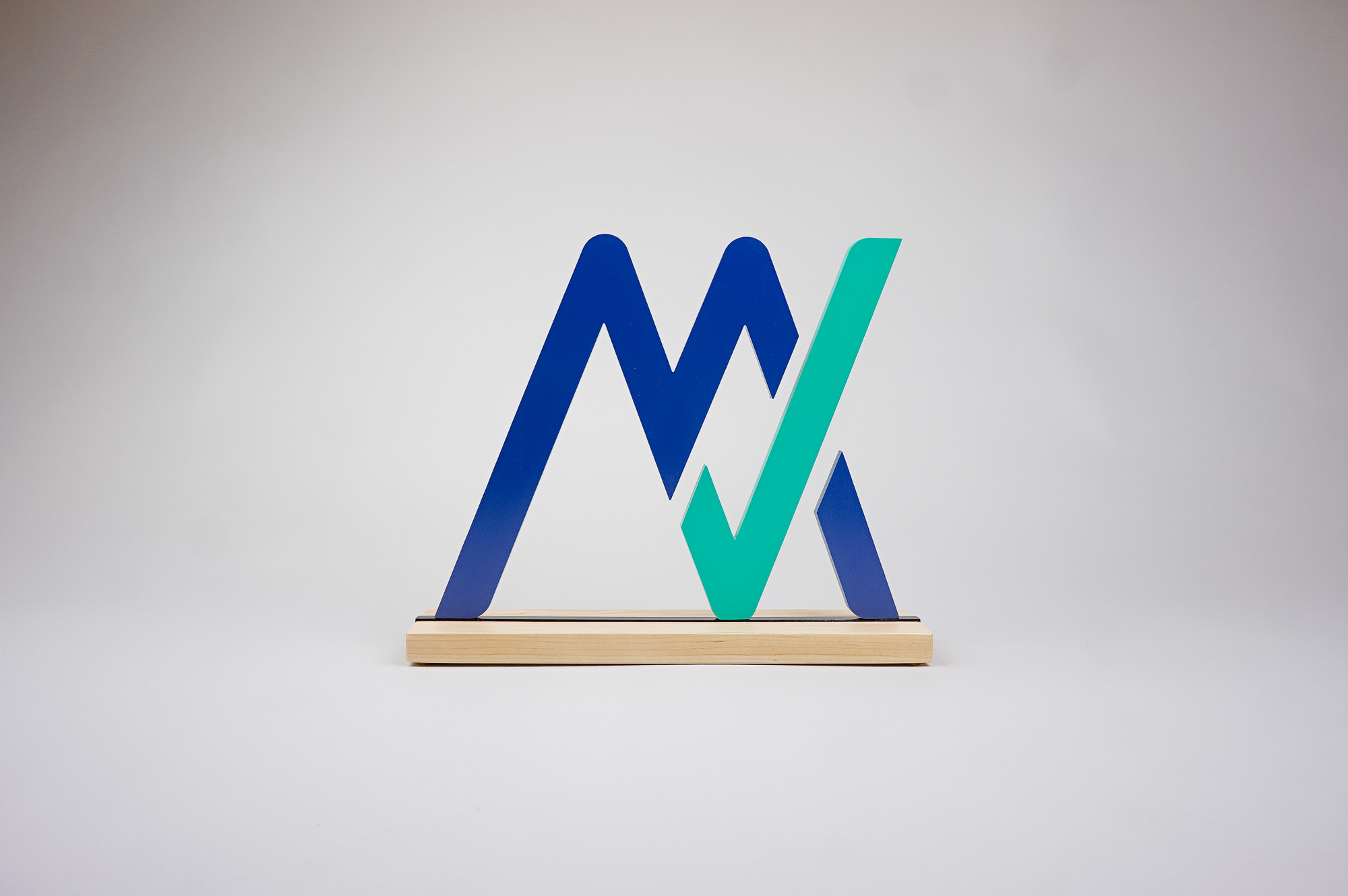 Freestanding blue and green logo on wood base for the office of MyVest, a company building enterprise wealth management technology for the digital age.