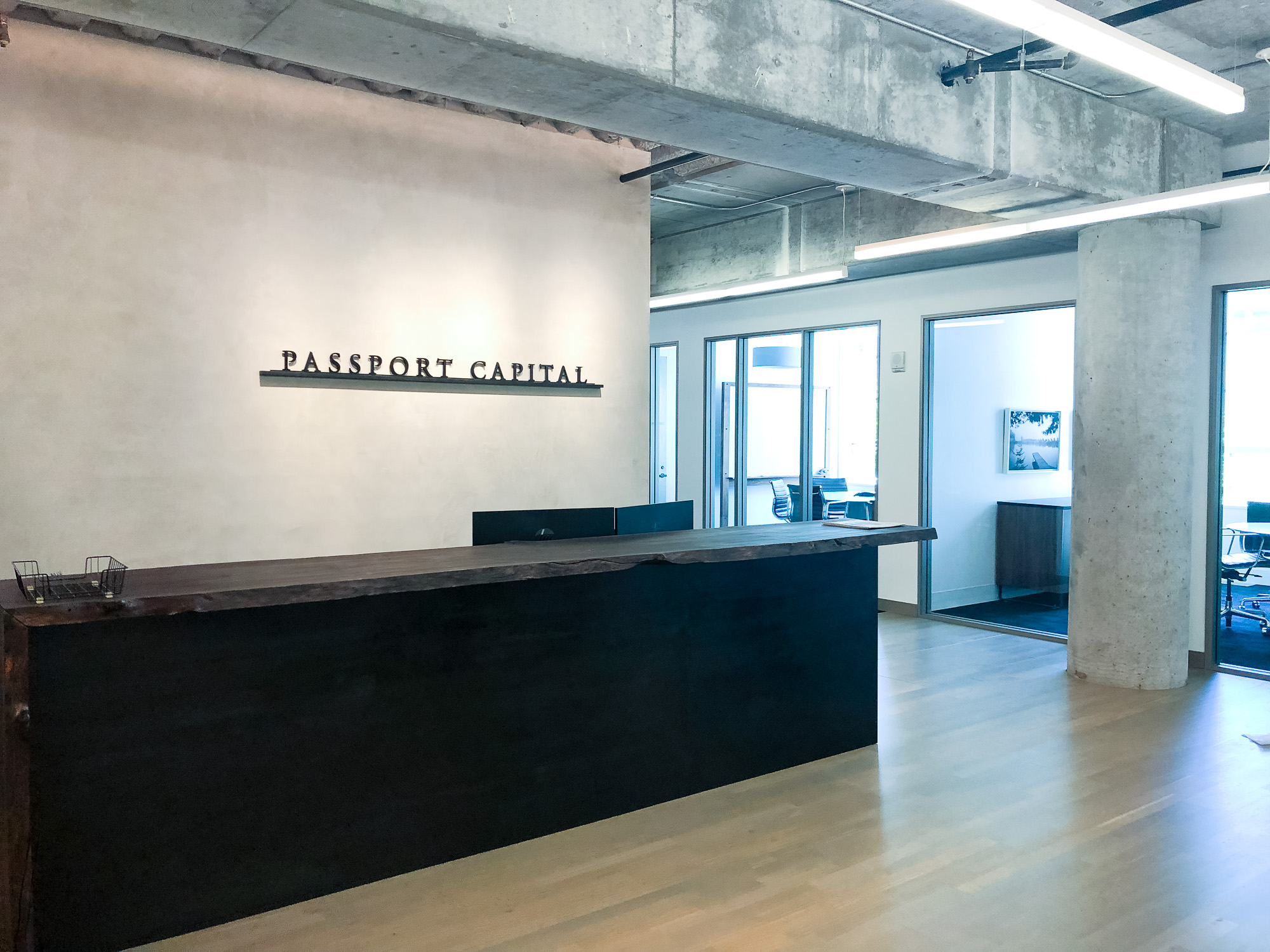 Black letters on shelf against concrete lobby wall at Passport Capital, a San Francisco-based, global thematic investment firm.