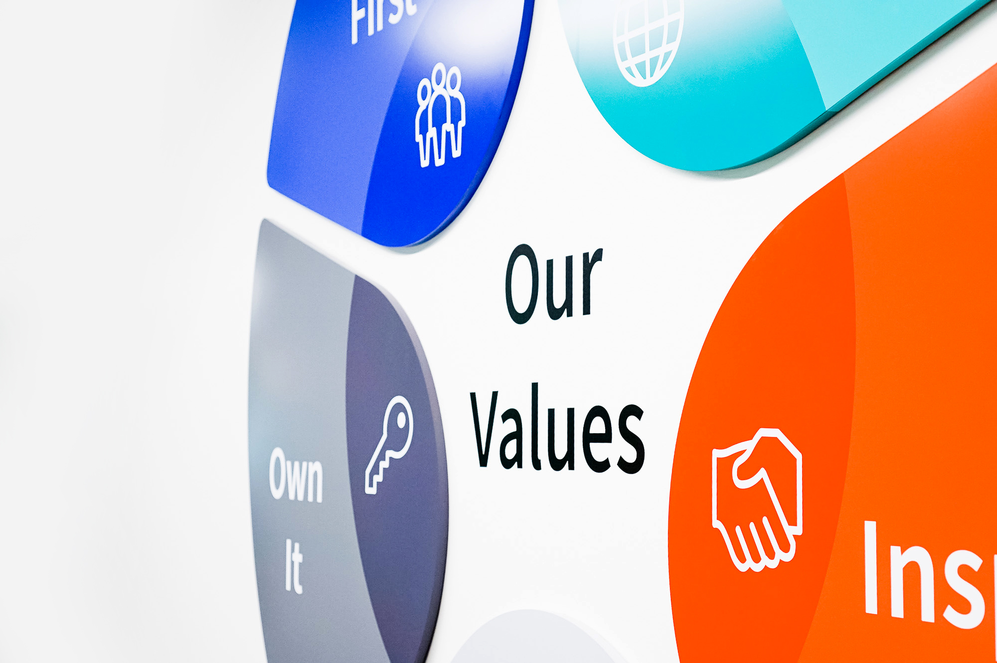 Dimensional, full-color company values graphic on white wall in the San Francisco office of Roostify, an integrated digital mortgage software platform.