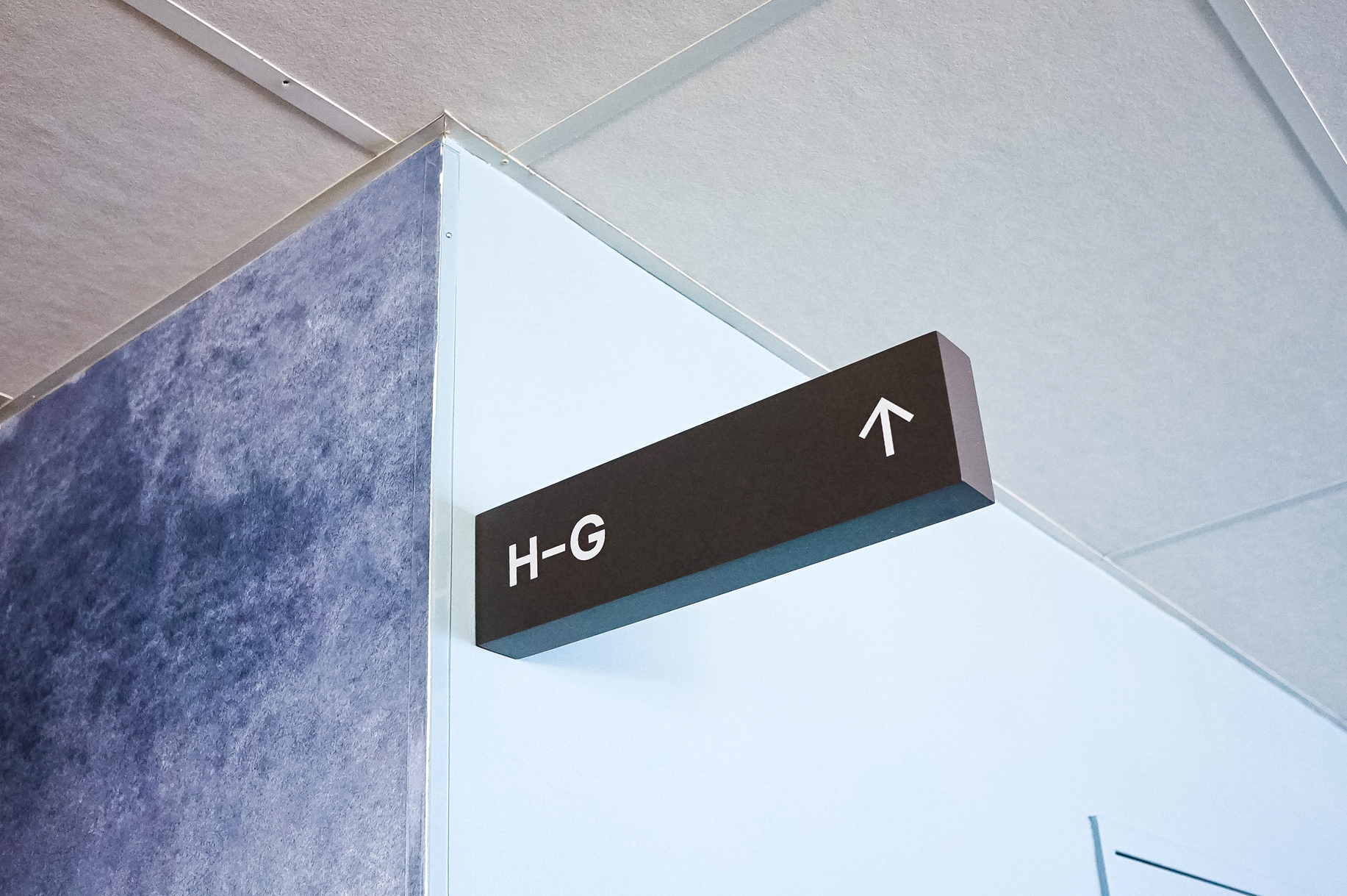 Overhead dark grey wayfinding sign with white text for a San Francisco office of Slack, an American cloud-based set of proprietary team collaboration tools and services. Overhead dark grey wayfinding sign with white text for a San Francisco office of Slack, an American cloud-based set of proprietary team collaboration tools and services.
