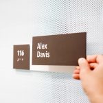 Changeable, minimal grey office ADA nameplate signs for Baker McKenzie, a multinational law firm.