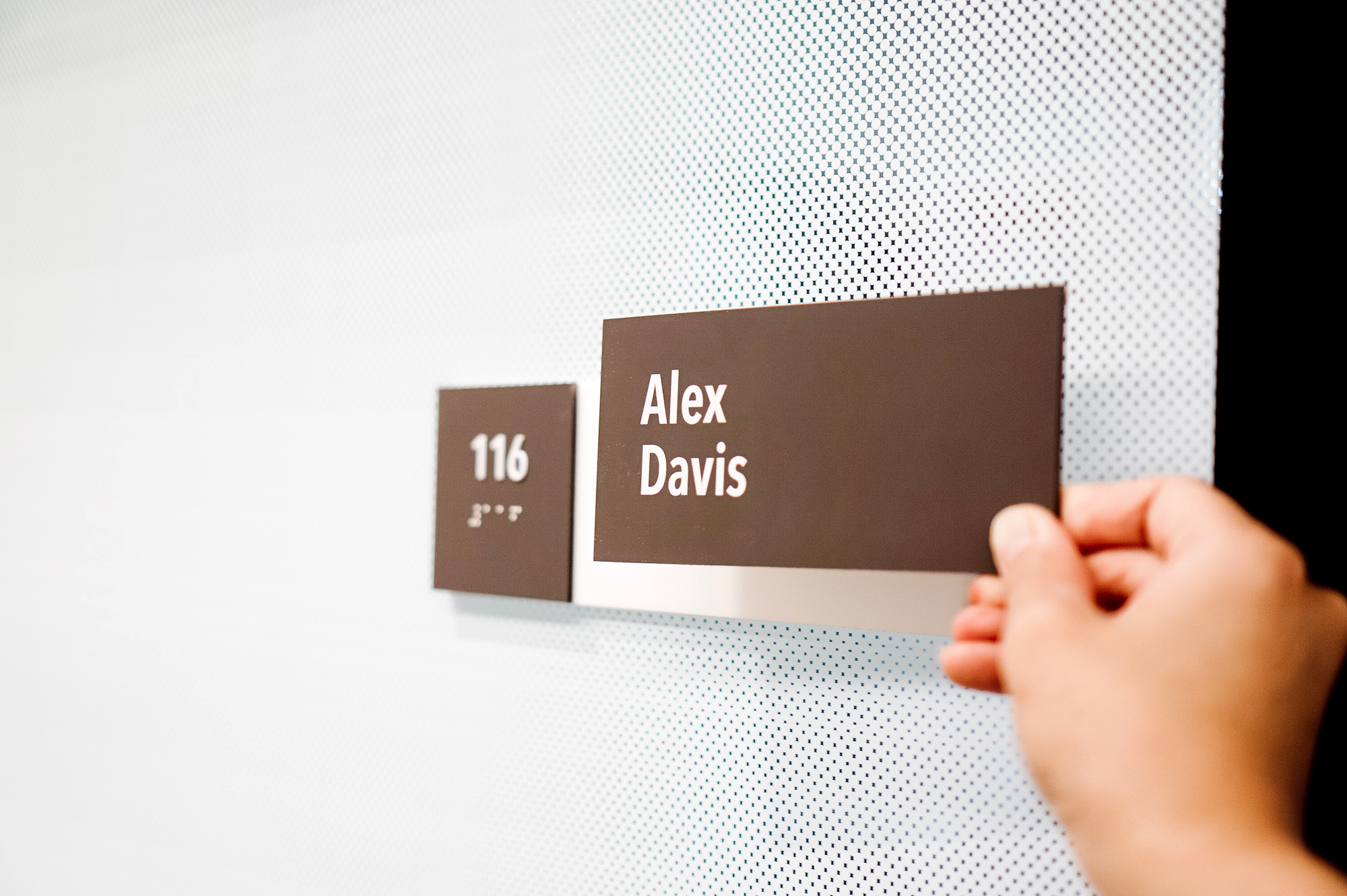 Changeable, minimal grey office ADA nameplate signs for Baker McKenzie, a multinational law firm.