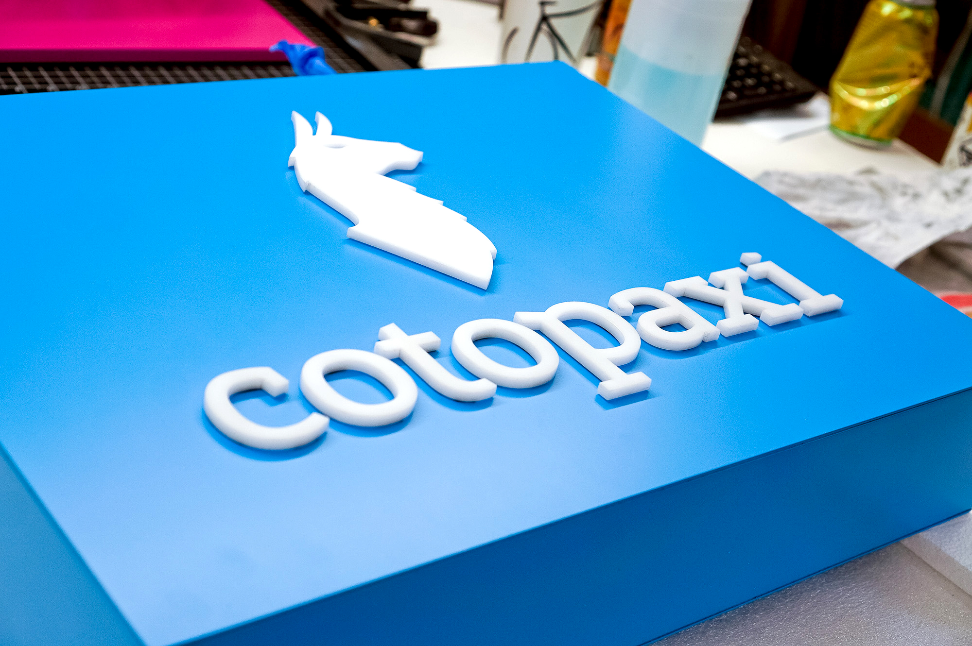 Blue boxed overhead retail sign with white artwork for Cotopaxi, a company that creates innovative outdoor products and experiences. Blue boxed overhead retail sign with white artwork for Cotopaxi, a company that creates innovative outdoor products and experiences.