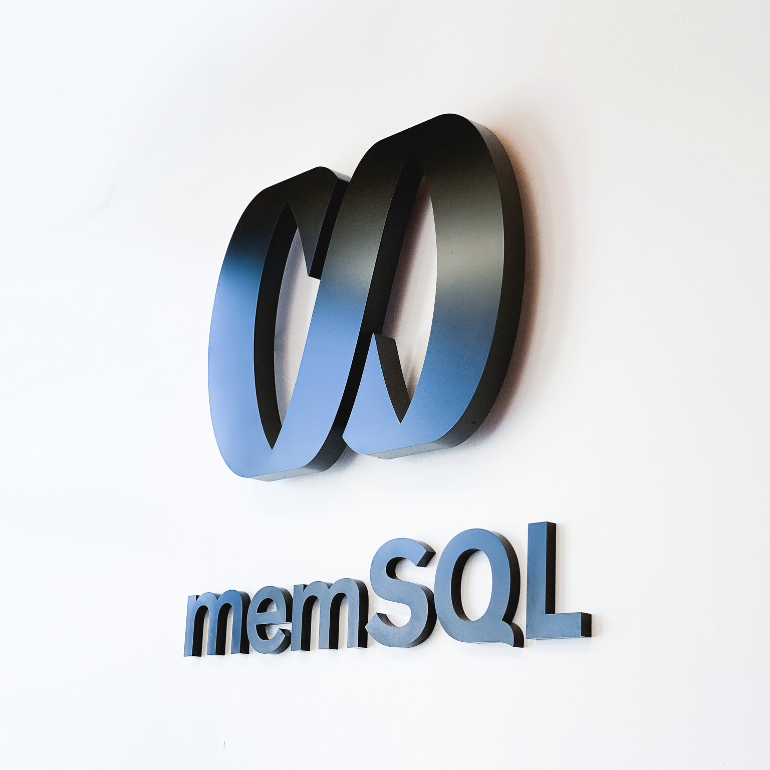 Illuminated black sign with back-lit purple lights for memSQL, a software company in San Francisco, California.