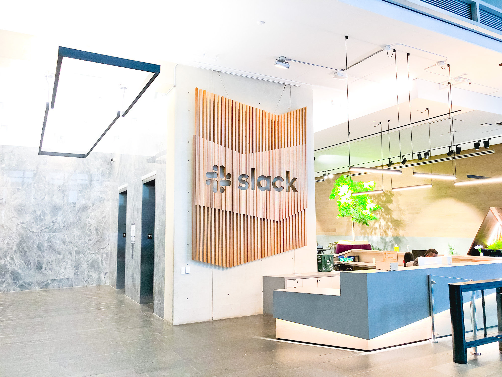 Modern, large-scale slat wood lobby sign on concrete wall at the San Francisco lobby of Slack, an American cloud-based set of team collaboration tools and services. Modern, large-scale slat wood lobby sign on concrete wall at the San Francisco lobby of Slack, an American cloud-based set of team collaboration tools and services.