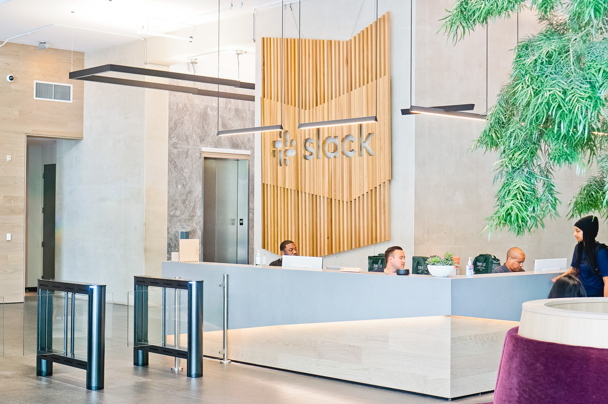 Modern, large-scale slat wood lobby sign on concrete wall at the San Francisco lobby of Slack, an American cloud-based set of team collaboration tools and services. Modern, large-scale slat wood lobby sign on concrete wall at the San Francisco lobby of Slack, an American cloud-based set of team collaboration tools and services.
