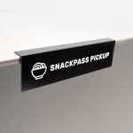 Overhanging black and white food pickup table sign for Snackpass, a social food app that makes ordering food more convenient, affordable and social.