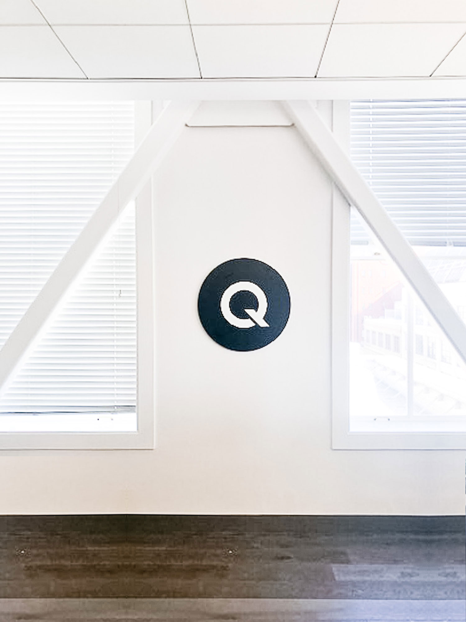 Black and white circular sign on white wall for the office of Qordoba, a content AI technology to help organizations achieve consistency and clarity across all types of content. Black and white circular sign on white wall for the office of Qordoba, a content AI technology to help organizations achieve consistency and clarity across all types of content.