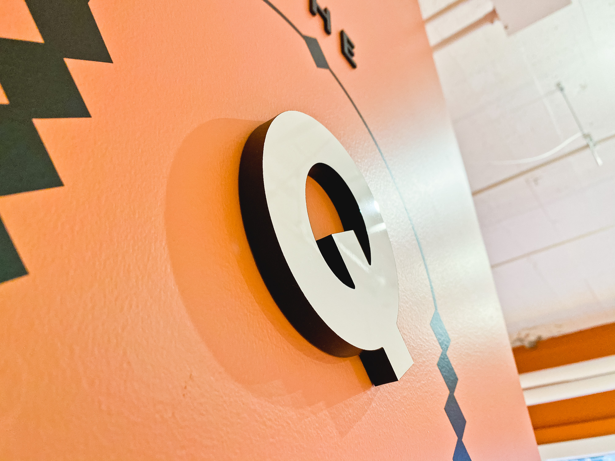 Multi-dimensional black and white “The Quiet Room” sign on salmon colored wall for the San Francisco expansion of The Wing, a network of work and community spaces designed for women. Multi-dimensional black and white