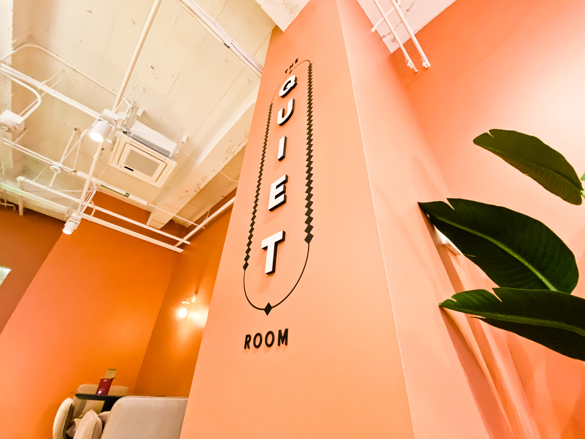 Multi-dimensional black and white “The Quiet Room” sign on salmon colored wall for the San Francisco expansion of The Wing, a network of work and community spaces designed for women. Multi-dimensional black and white