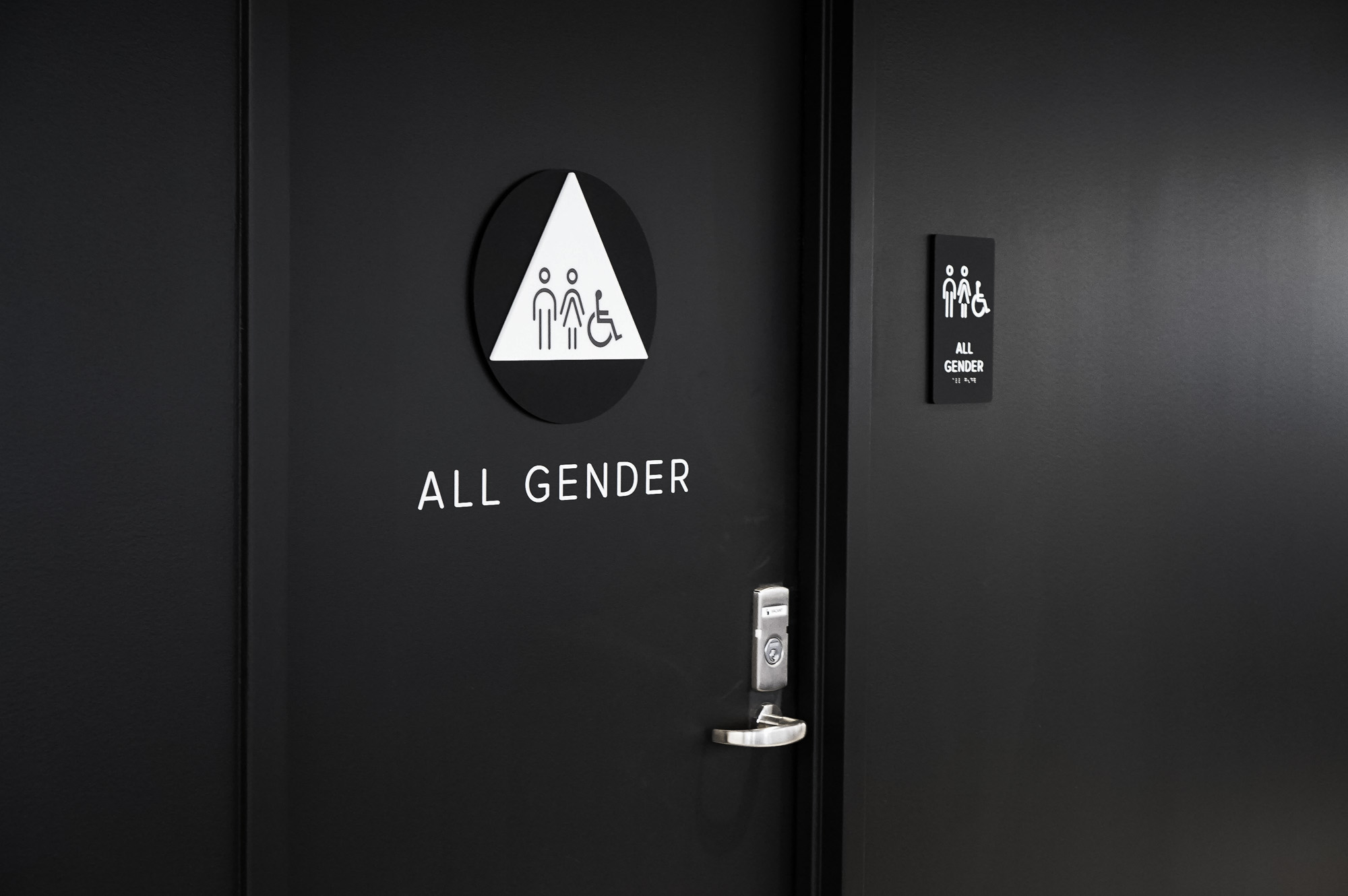 Modern, matte black restroom signs with white icons on black walls for the restrooms of Scale, a San Francisco based company delivering high quality training data for AI applications such as self-driving cars, mapping, AR/VR, robotics, and more.