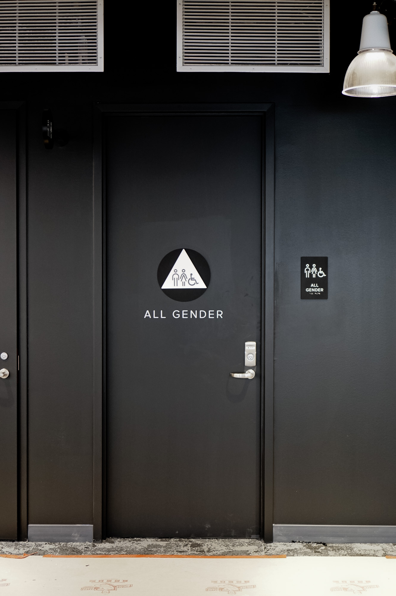 Modern, matte black restroom signs with white icons on black walls for the restrooms of Scale, a San Francisco based company delivering high quality training data for AI applications such as self-driving cars, mapping, AR/VR, robotics, and more.