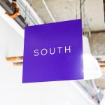 Minimal, multi-colored north, south, east, and west suspended directional signs for Scale, a San Francisco based company delivering high quality training data for AI applications such as self-driving cars, mapping, AR/VR, robotics, and more.