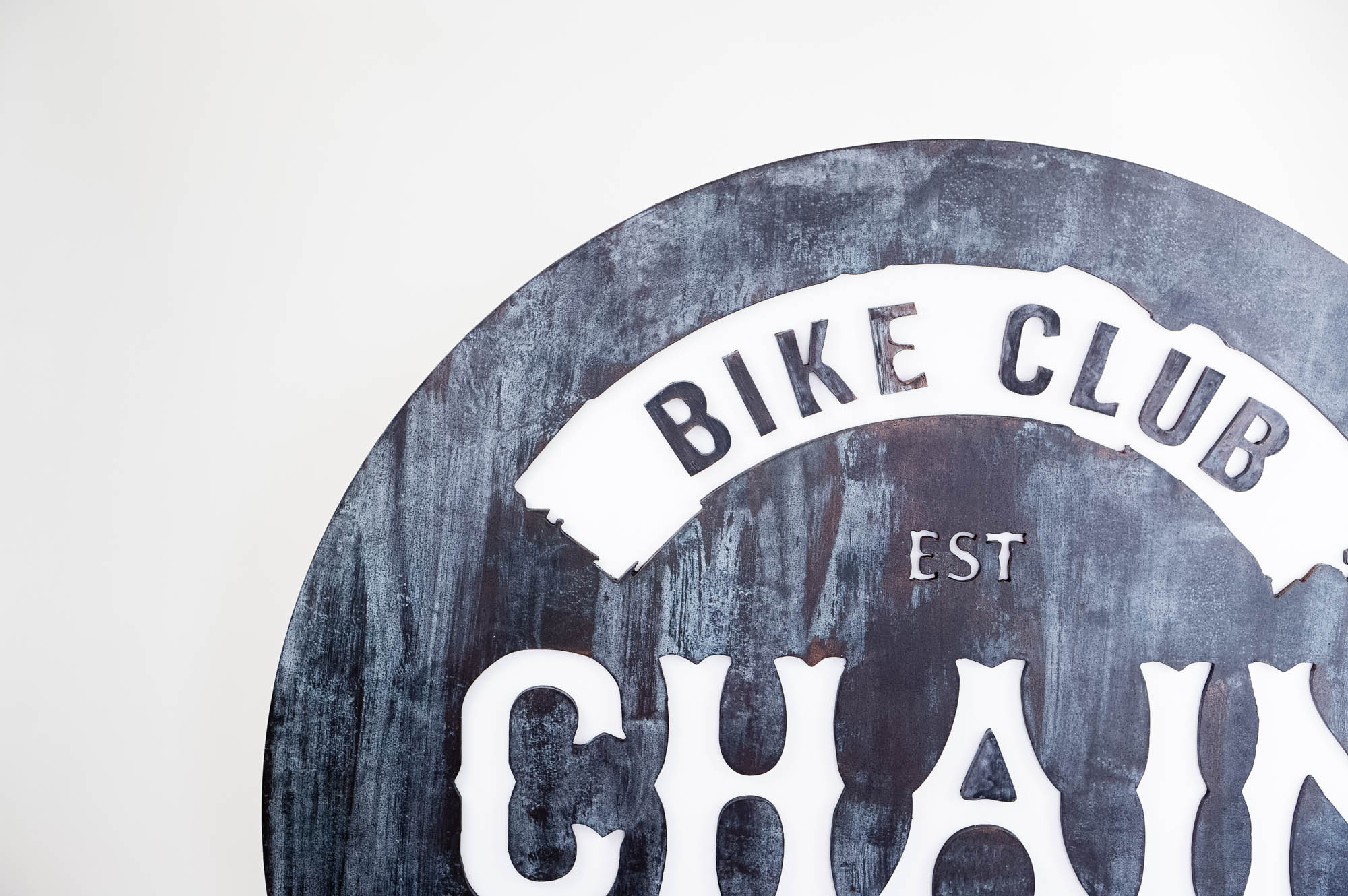 Faux rusty metal illuminated sign for Chain, a cycling studio in Styles Studios Fitness, a fitness club in Peoria, IL.