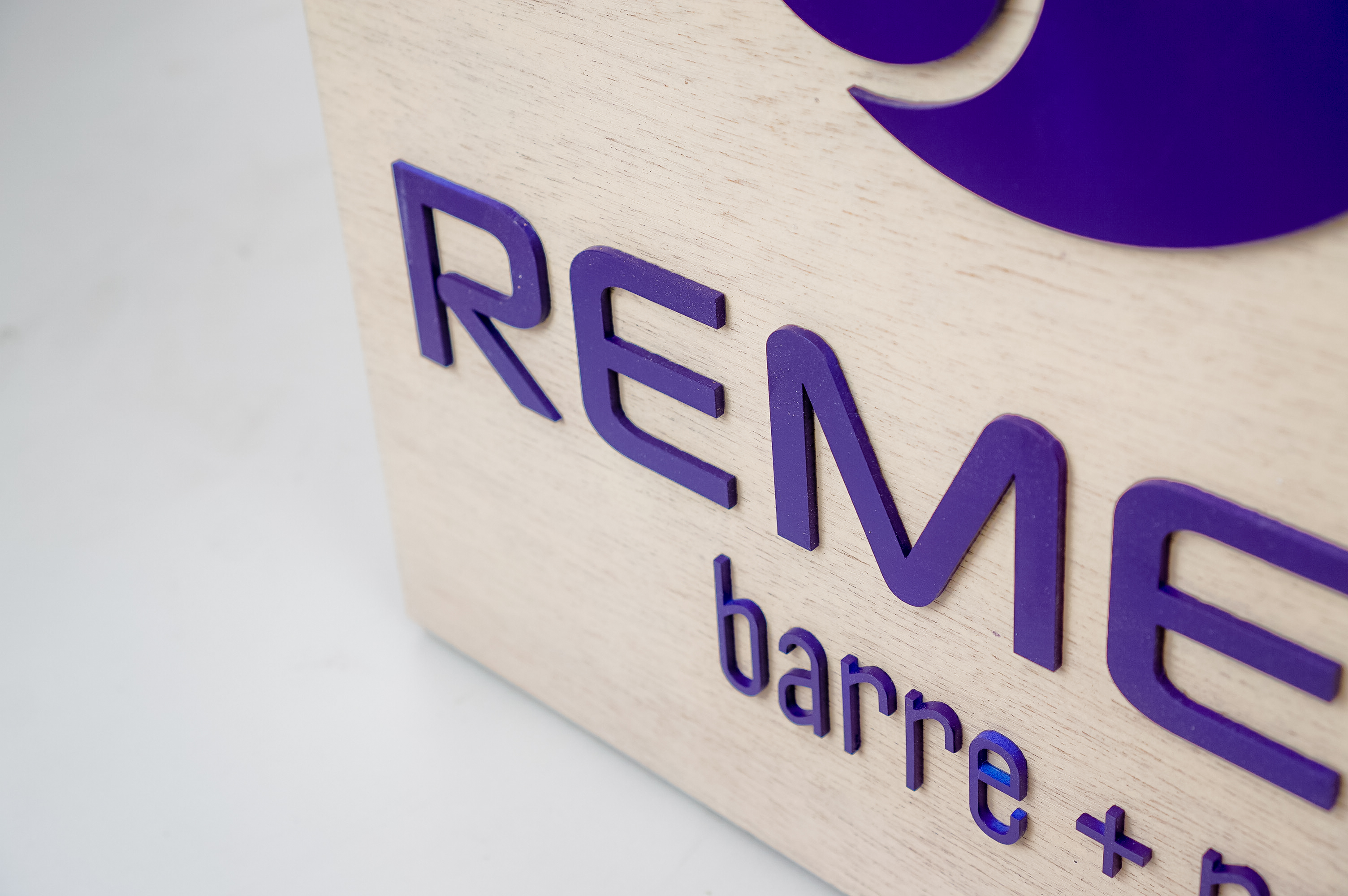 Hanging wood blade sign with purple logo for Remedy Barre and Foam Rolling, an independent studio offering barre & foam-roller stretching classes in Oakland CA. Hanging wood blade sign with purple logo for Remedy Barre and Foam Rolling, an independent studio offering barre & foam-roller stretching classes in Oakland CA.