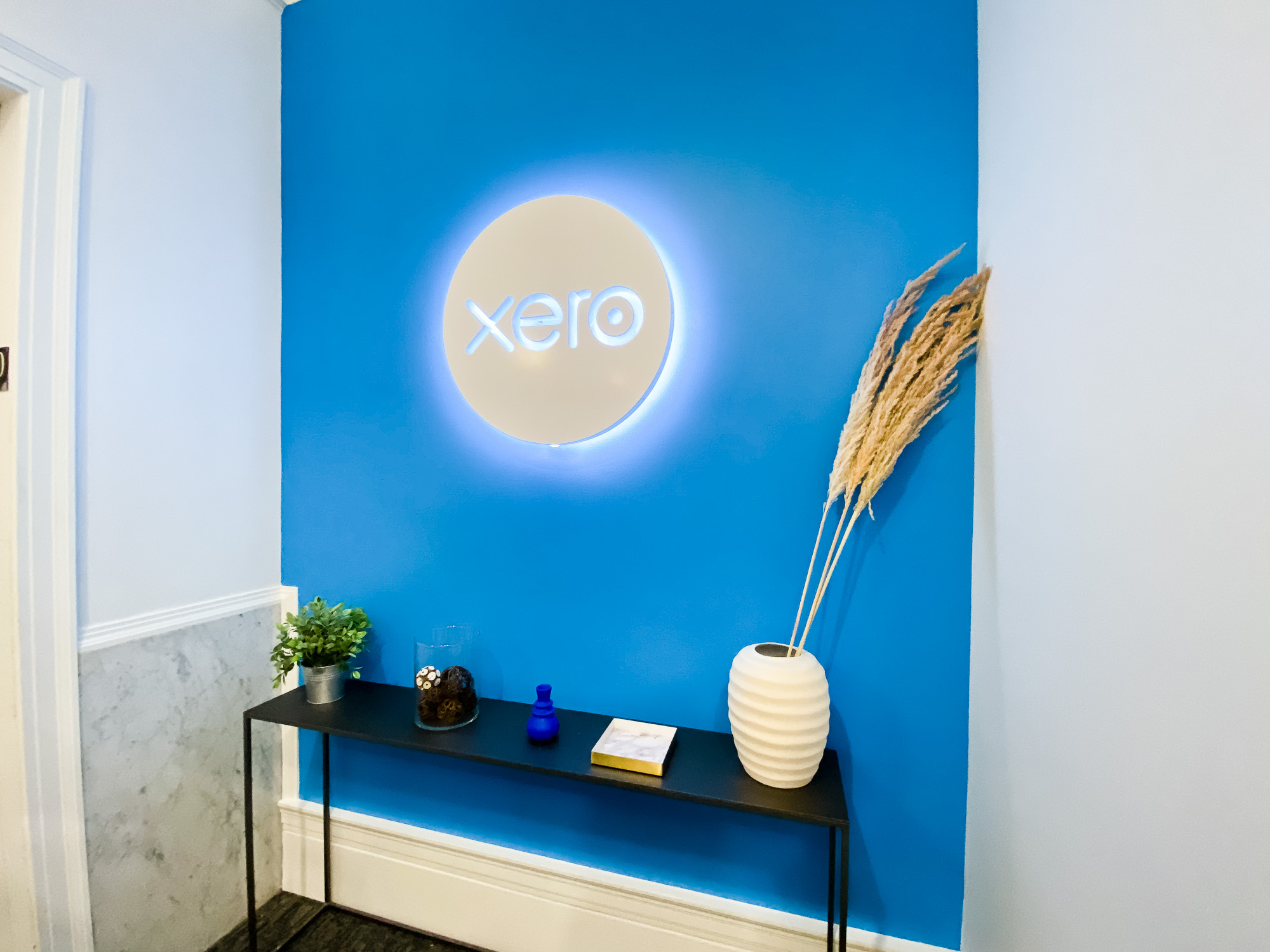 Illuminated, back-lit white sign on blue lobby wall for Xero, a cloud-based accounting software platform for small and medium-sized businesses. Illuminated, back-lit white sign on blue lobby wall for Xero, a cloud-based accounting software platform for small and medium-sized businesses.