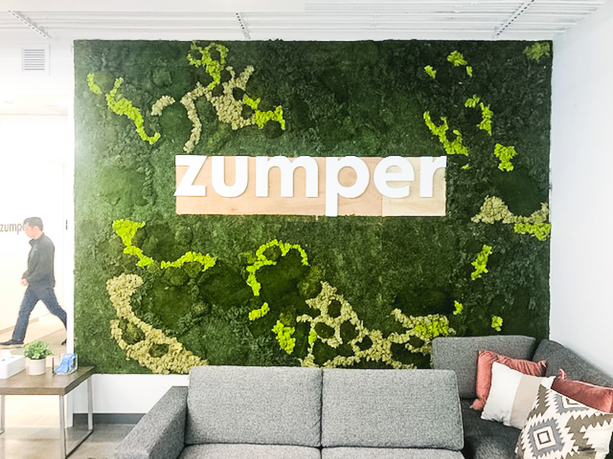 White letters on moss art wall for the lobby of Zumper, a full-service rental platform.