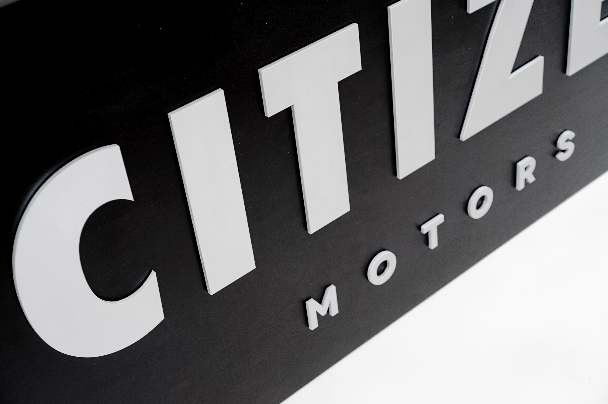 Black sign with silver letters for Citizen Motors, a shop that builds and restores classic vehicles in the San Francisco Bay Area.