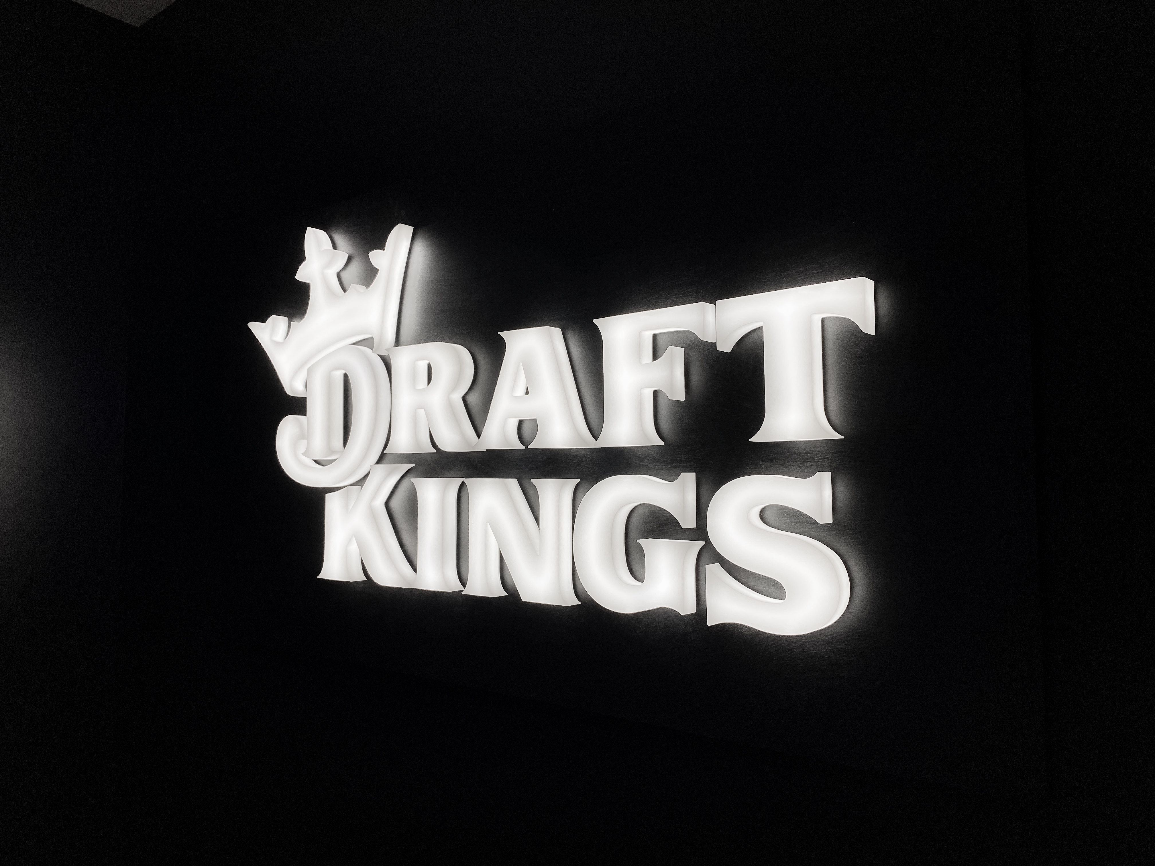 Illuminated, face-lit white logo on a black painted backer/wall for the San Francisco office of Draft Kings, an American daily fantasy sports contest and sports betting provider. Illuminated, face-lit white logo on a black painted backer/wall for the San Francisco office of Draft Kings, an American daily fantasy sports contest and sports betting provider.