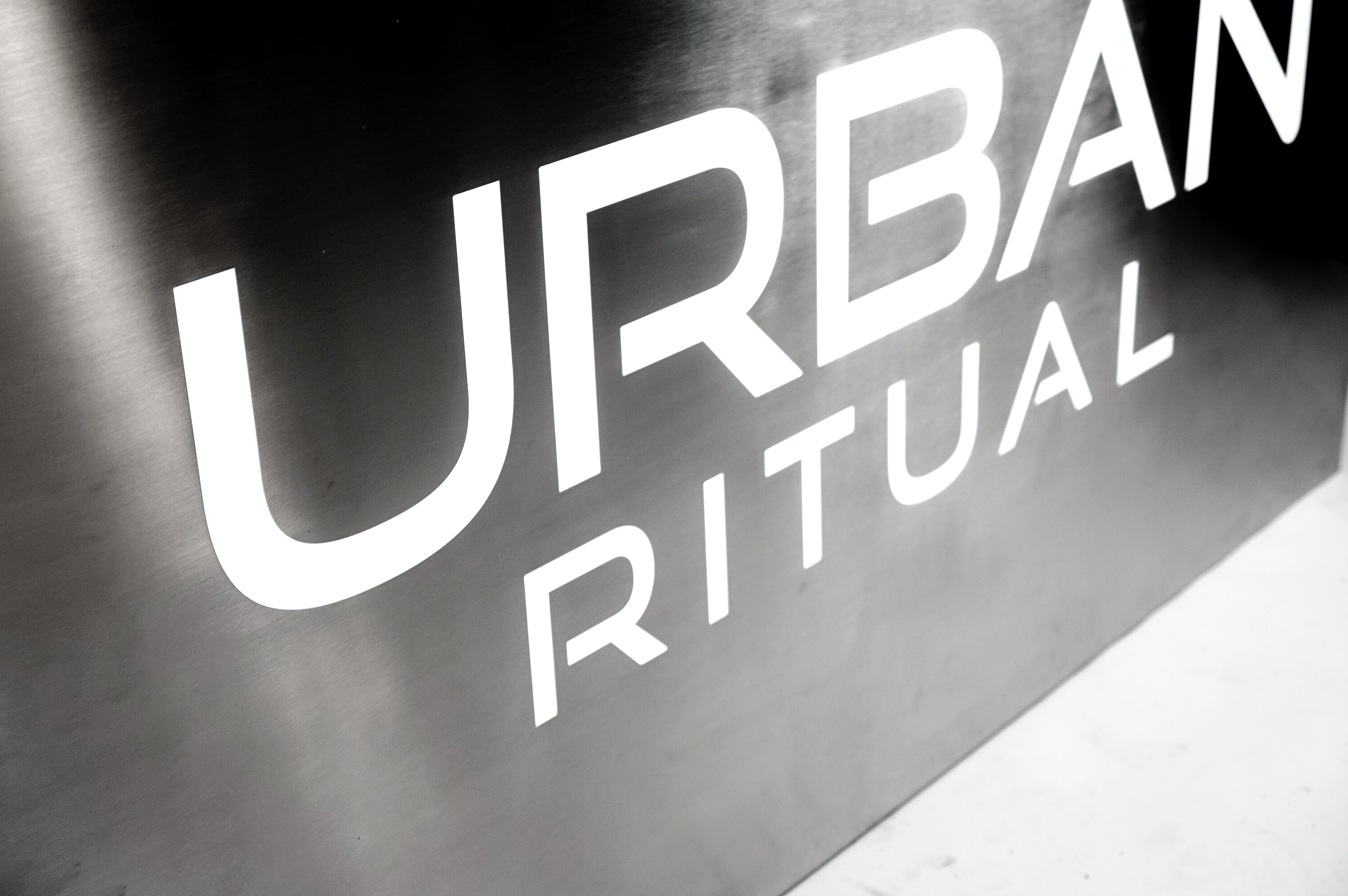 Brushed steel, interior-lit, large square wall sign for Urban Ritual, a fitness studio located in Styles Studios, a boutique fitness studio in Peoria, IL.