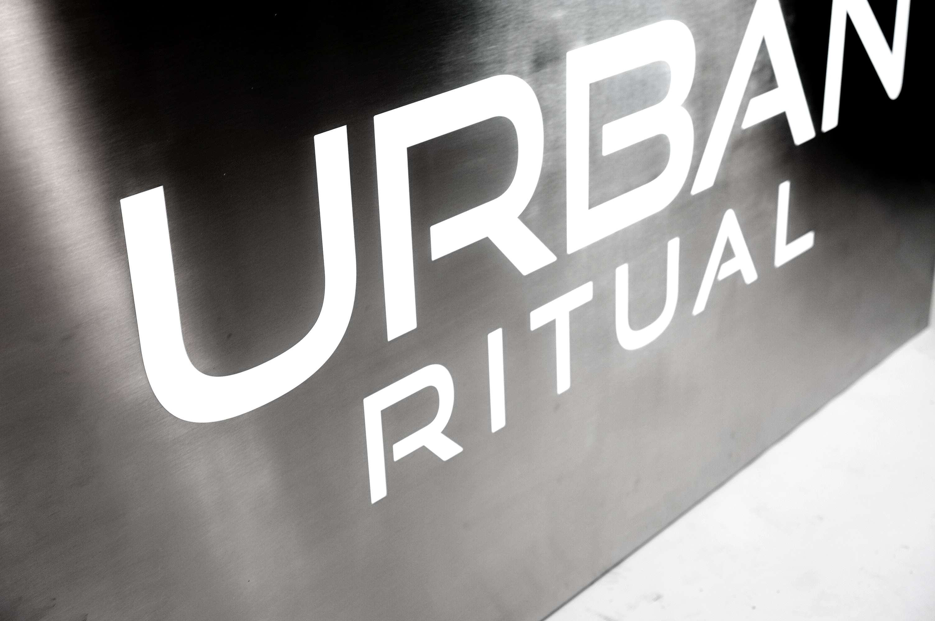 Brushed steel, interior-lit, large square wall sign for Urban Ritual, a fitness studio located in Styles Studios, a boutique fitness studio in Peoria, IL. Brushed steel, interior-lit, large square wall sign for Urban Ritual, a fitness studio located in Styles Studios, a boutique fitness studio in Peoria, IL.